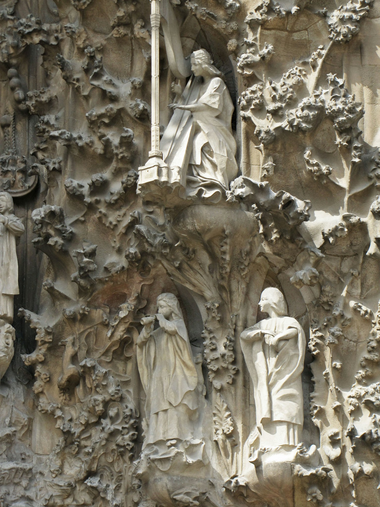 Détail d'une sculpture à la Sagrada Familia avec des figures de saints sculptées dans la pierre
