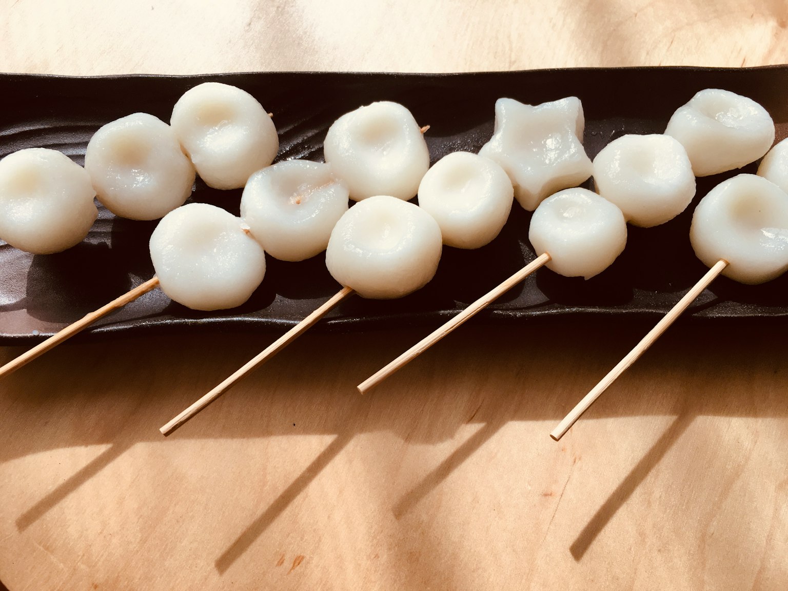 Japanese wagashi displayed on skewers with various shapes