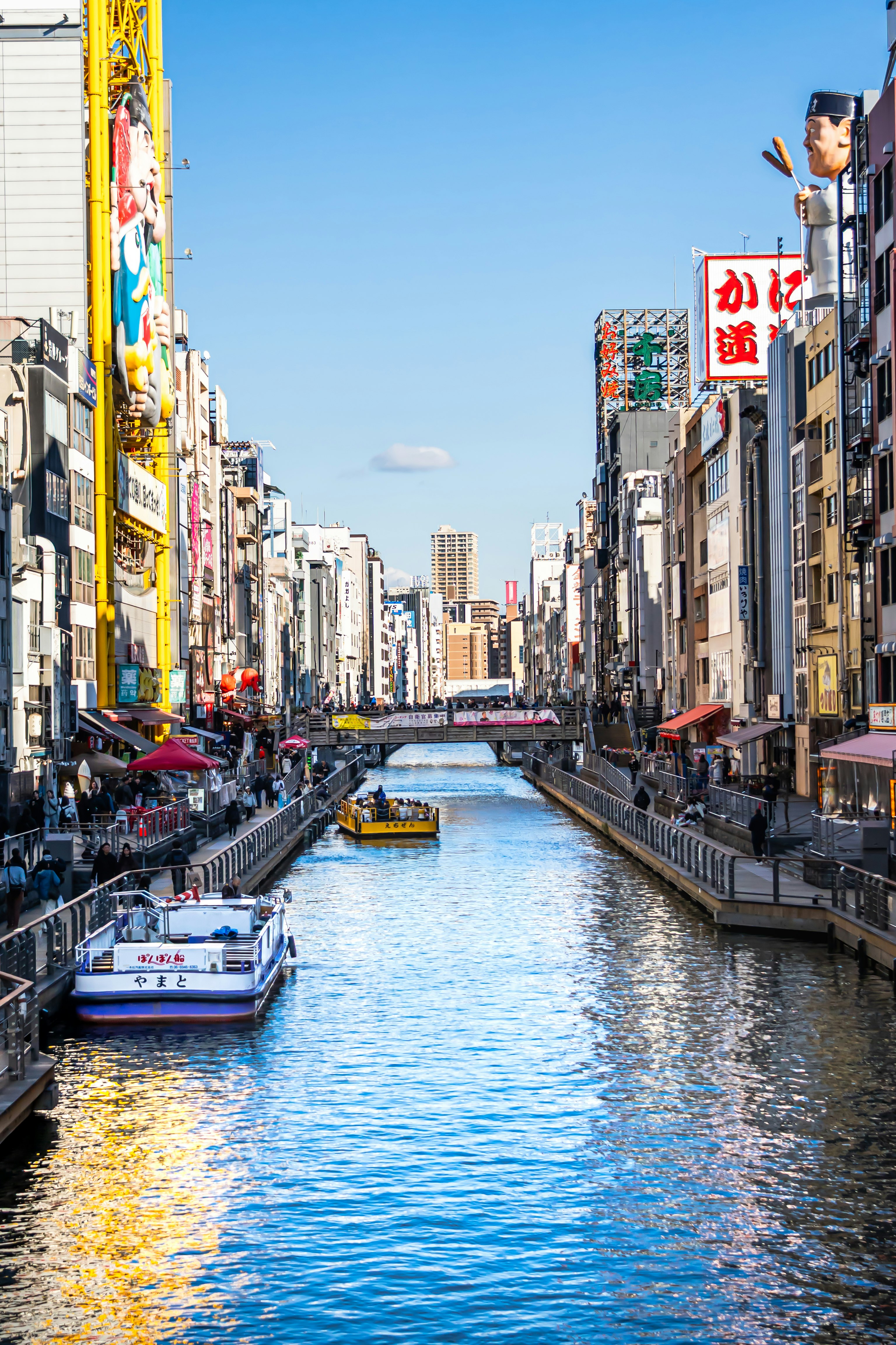 ถนนย่านการค้าริมคลองในโอซาก้าพร้อมเรือ