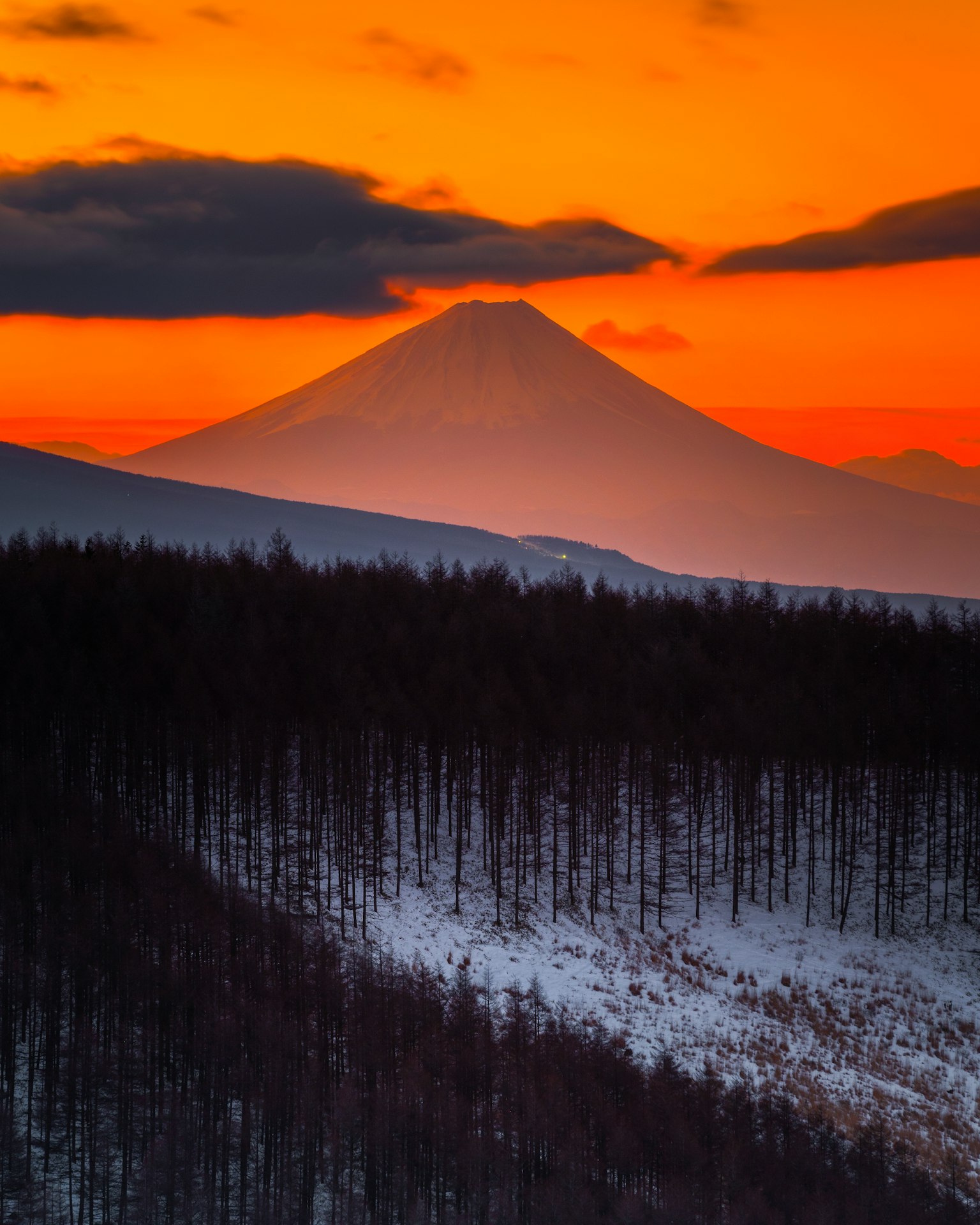 Monte Fuji silueteado contra un vibrante atardecer naranja