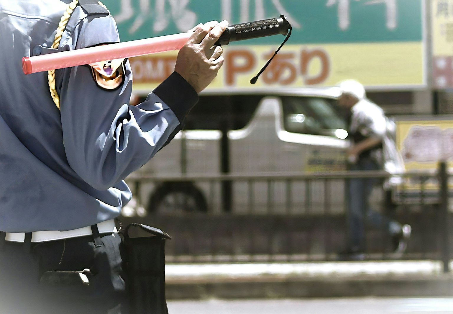 Agent de police dirigeant la circulation tenant une matraque rouge