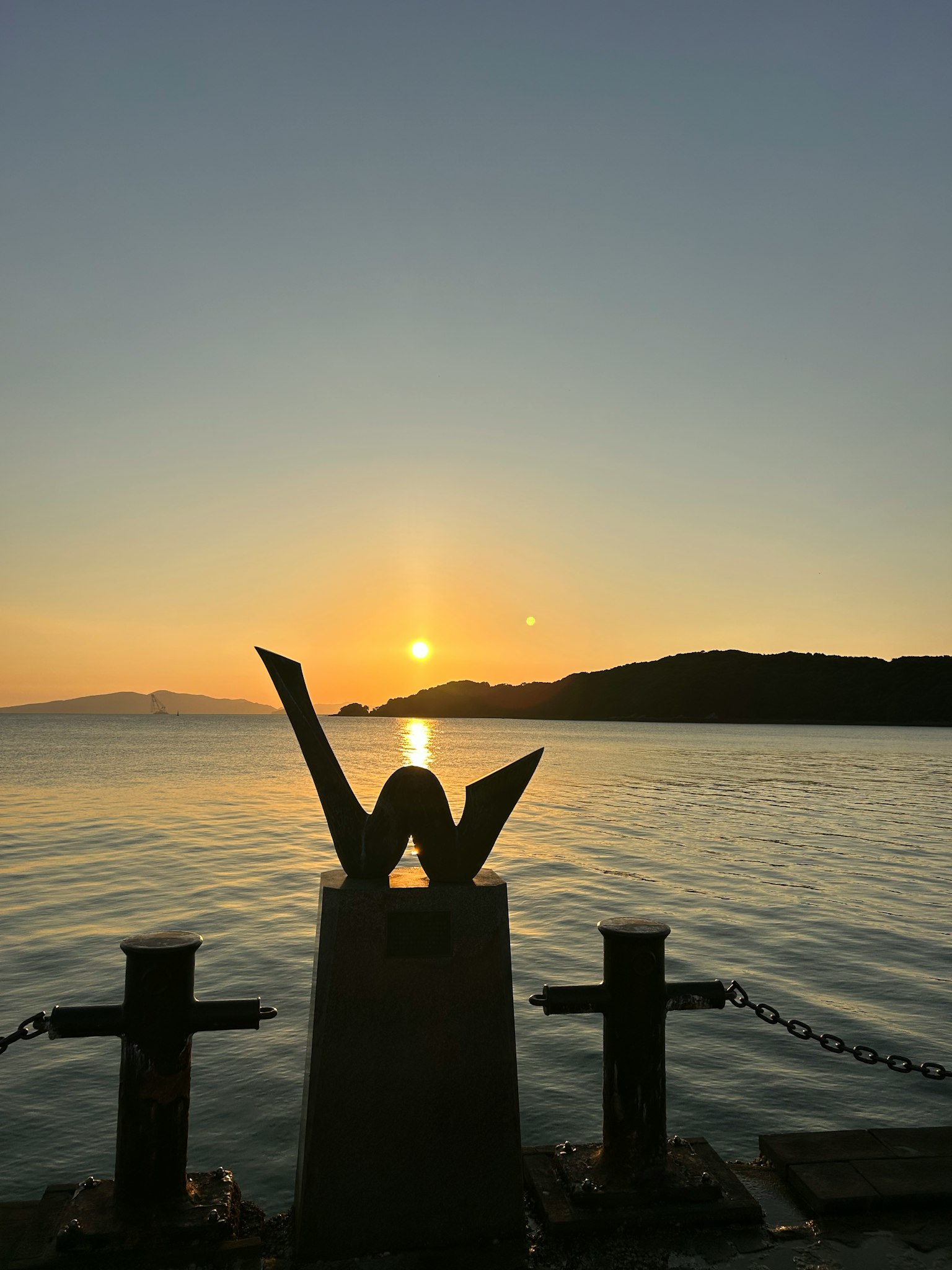 海上日落与前景的象征性雕塑