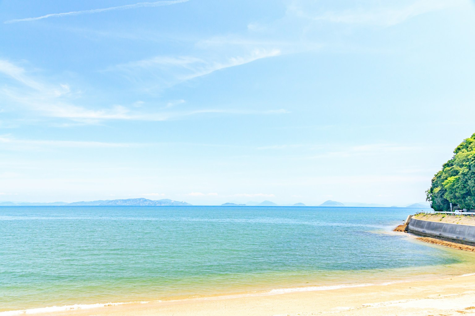 Vue panoramique de la mer bleue et du ciel avec une plage de sable