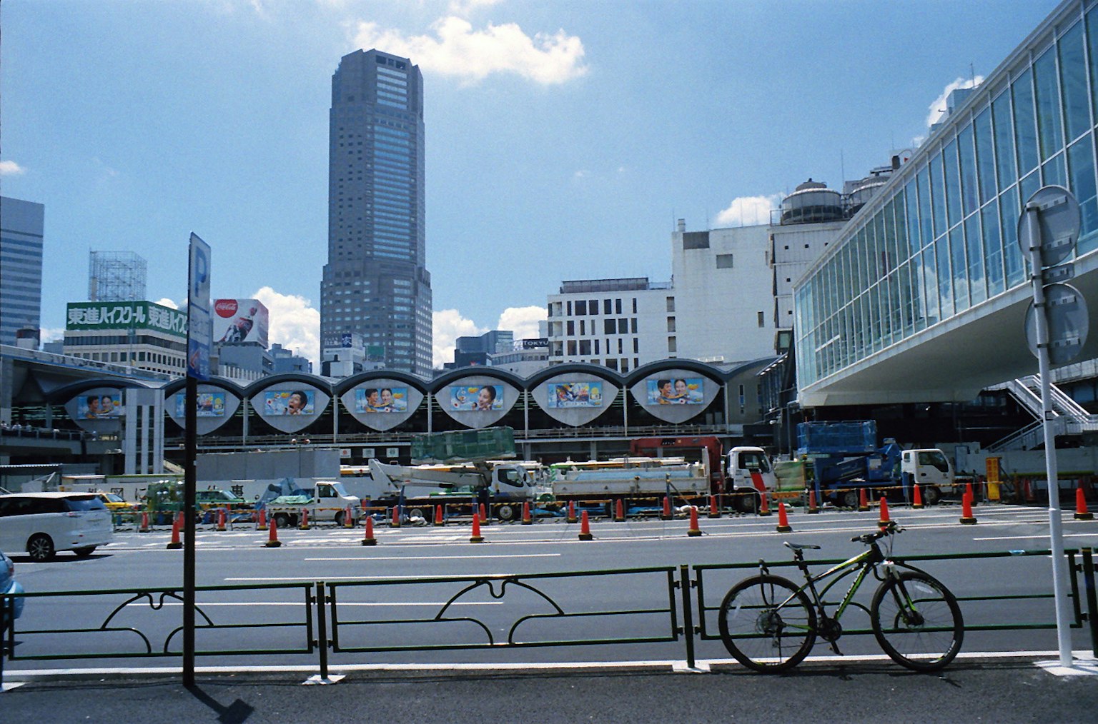 Urban landscape with skyscrapers and blue sky bicycle parked in front of a barrier near a construction area