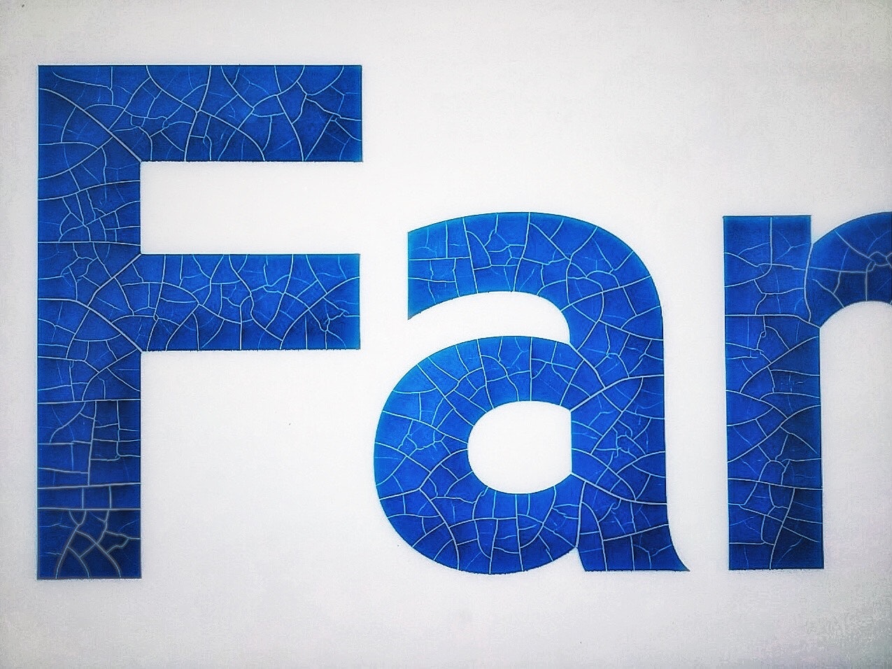 青いタイル調の壁面に「FA」のロゴがある看板