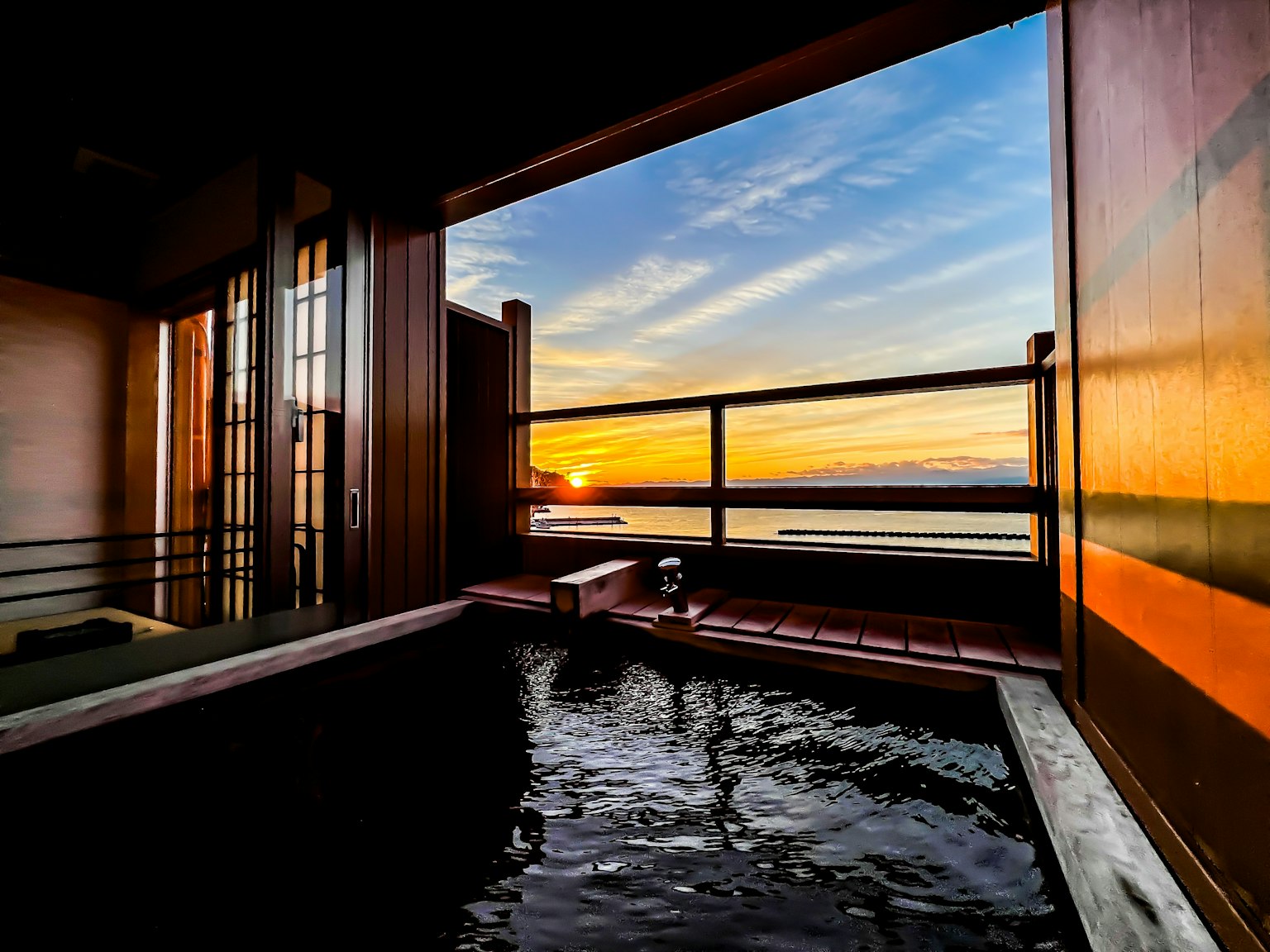 Baño al aire libre con vista al mar al atardecer