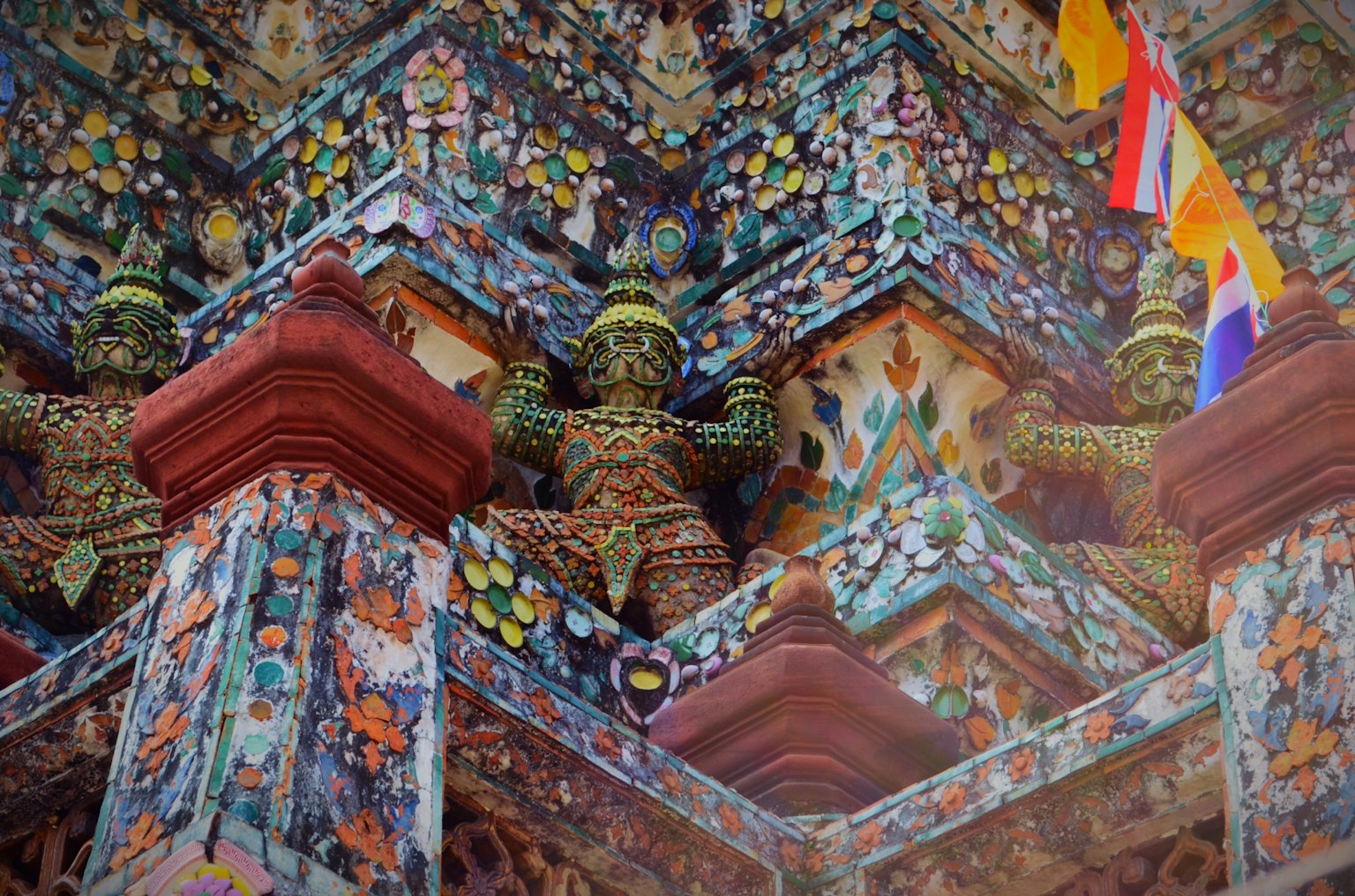 Bunte Fliesen und Skulpturen an der Außenwand eines Tempels mit aufwendigen Verzierungen