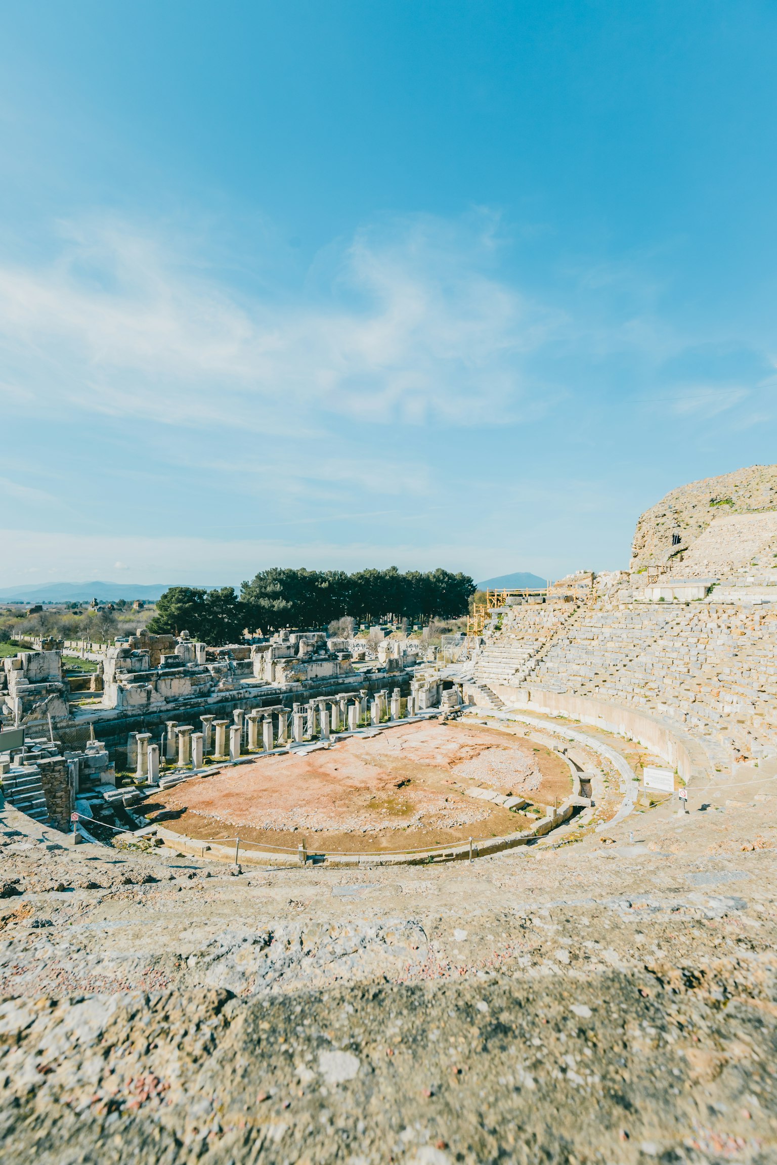 Rovine antiche di un teatro circolare sotto un cielo blu