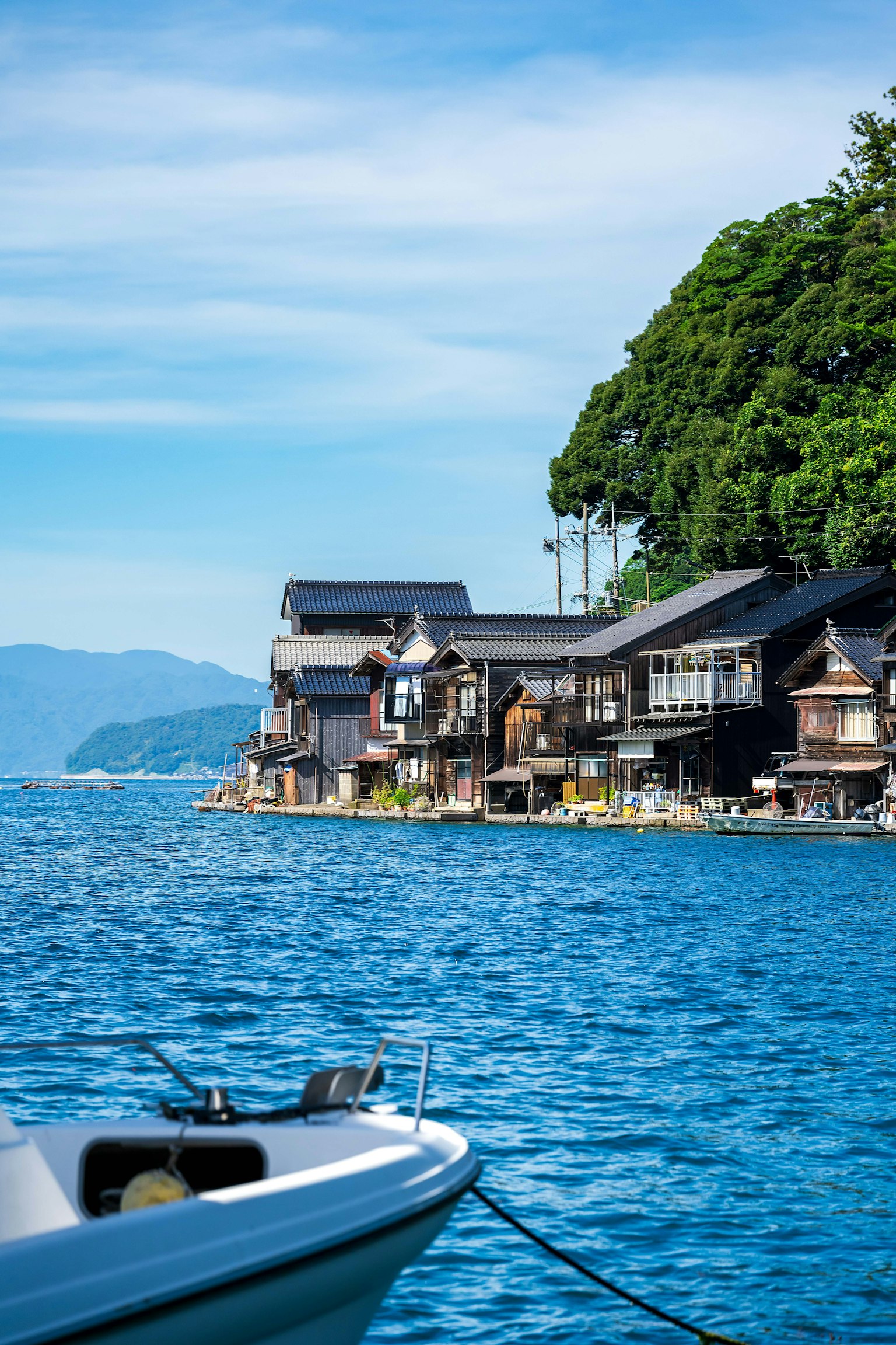 Malerscher Blick auf ein traditionelles japanisches Fischerdorf an der Küste mit einem Boot