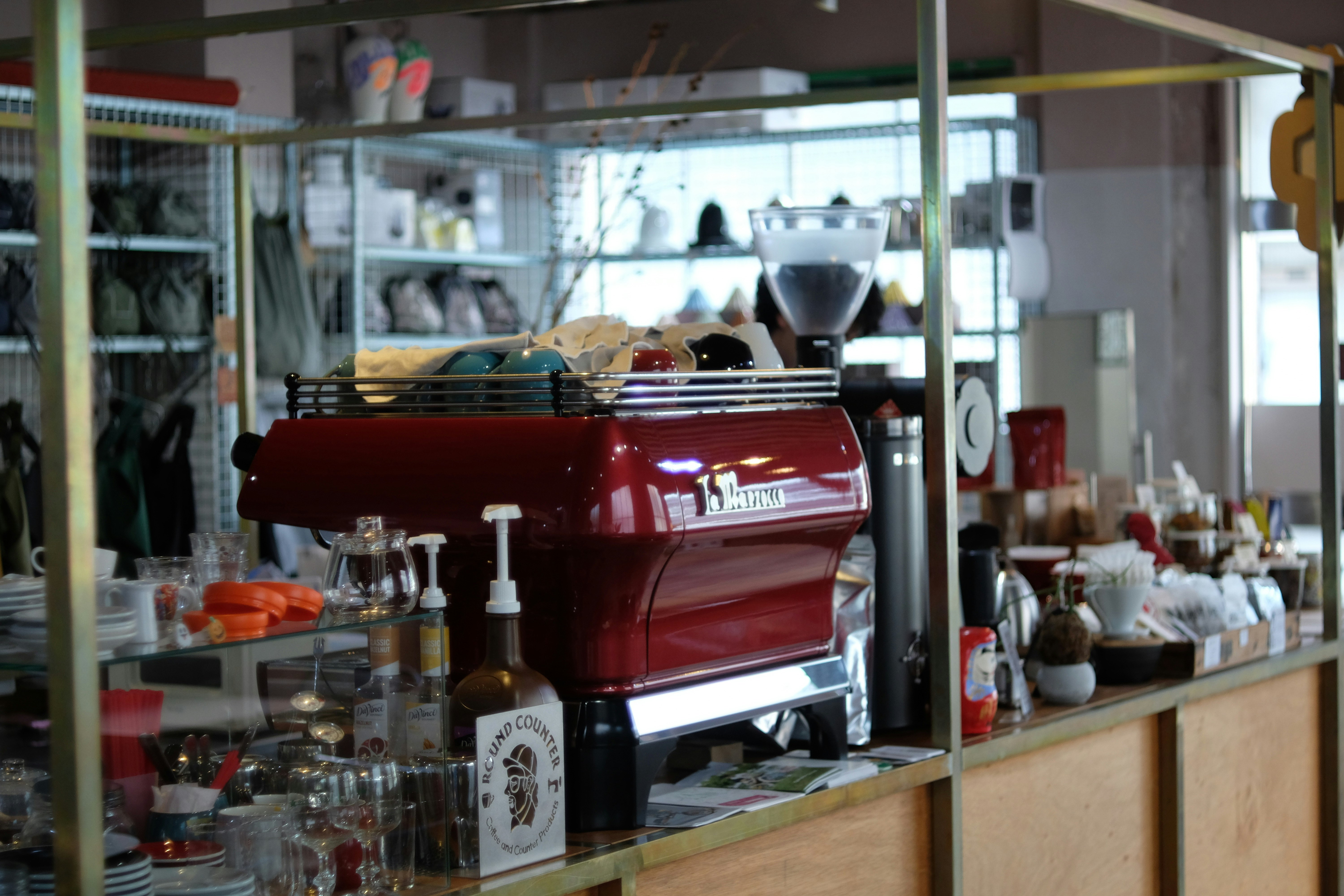 カウンター越しに並ぶコーヒー器具と店内のショーケース