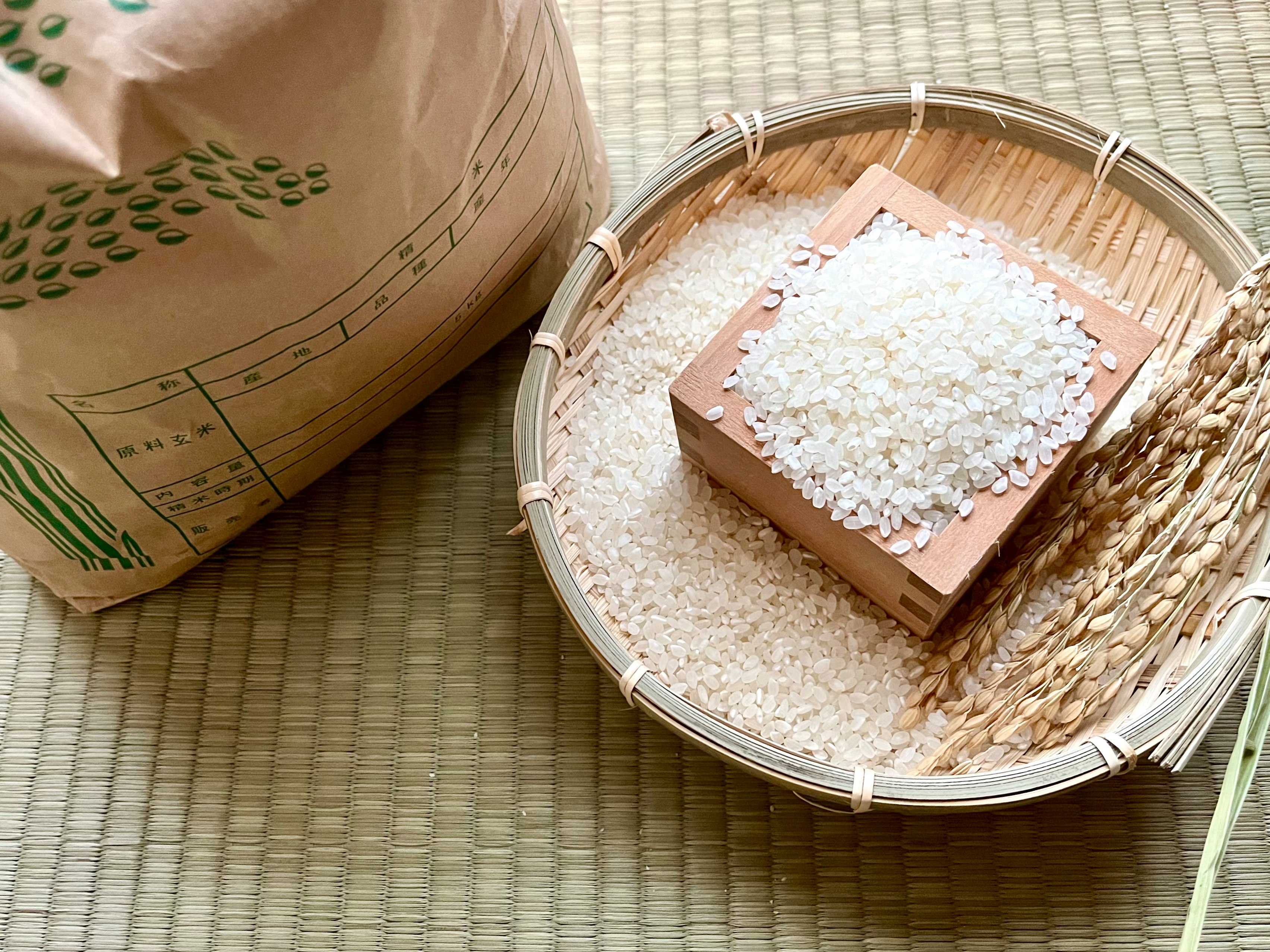 米袋と竹かごに入った白米の粒