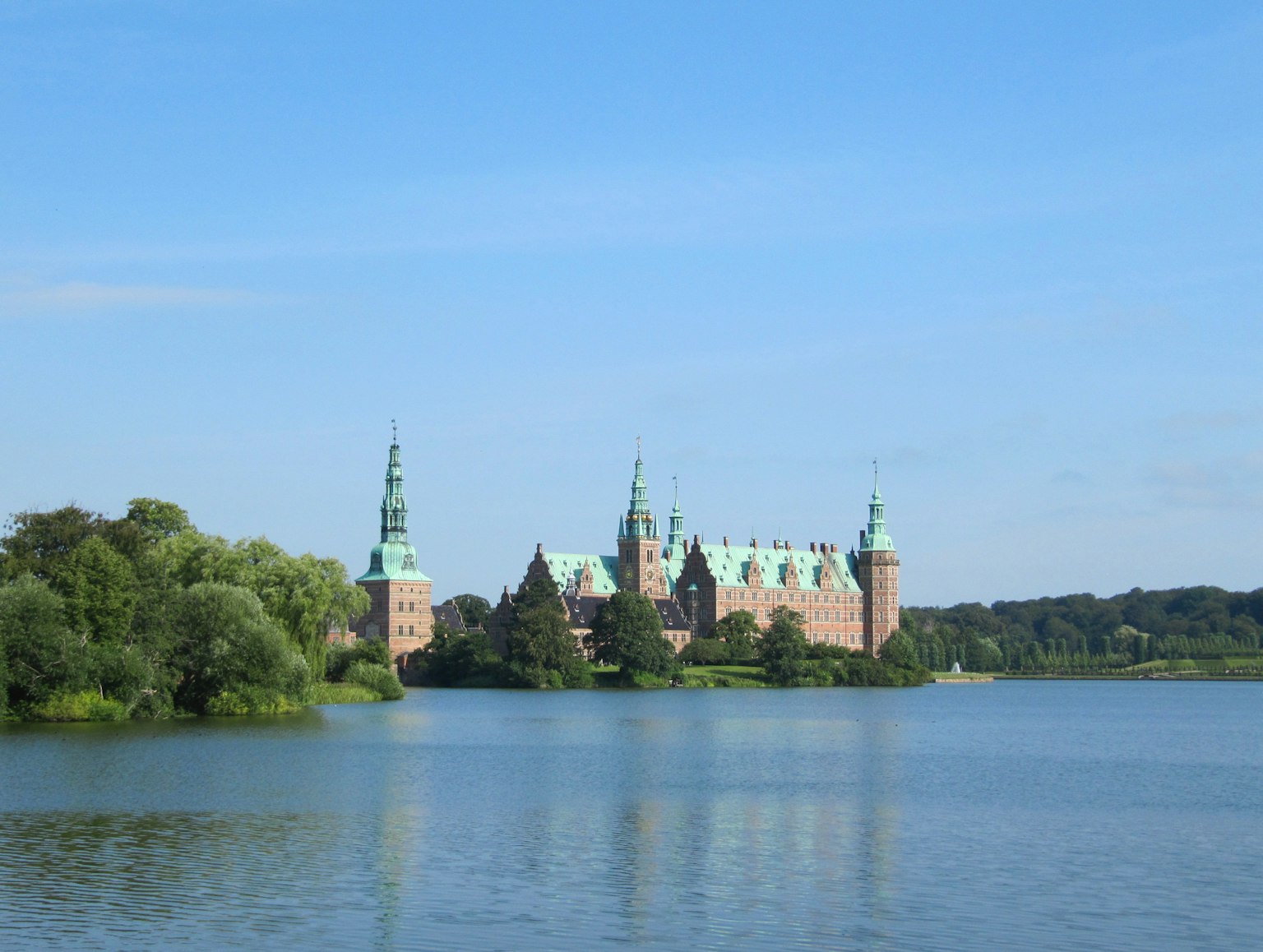 Vista escénica de un castillo histórico junto a un lago tranquilo