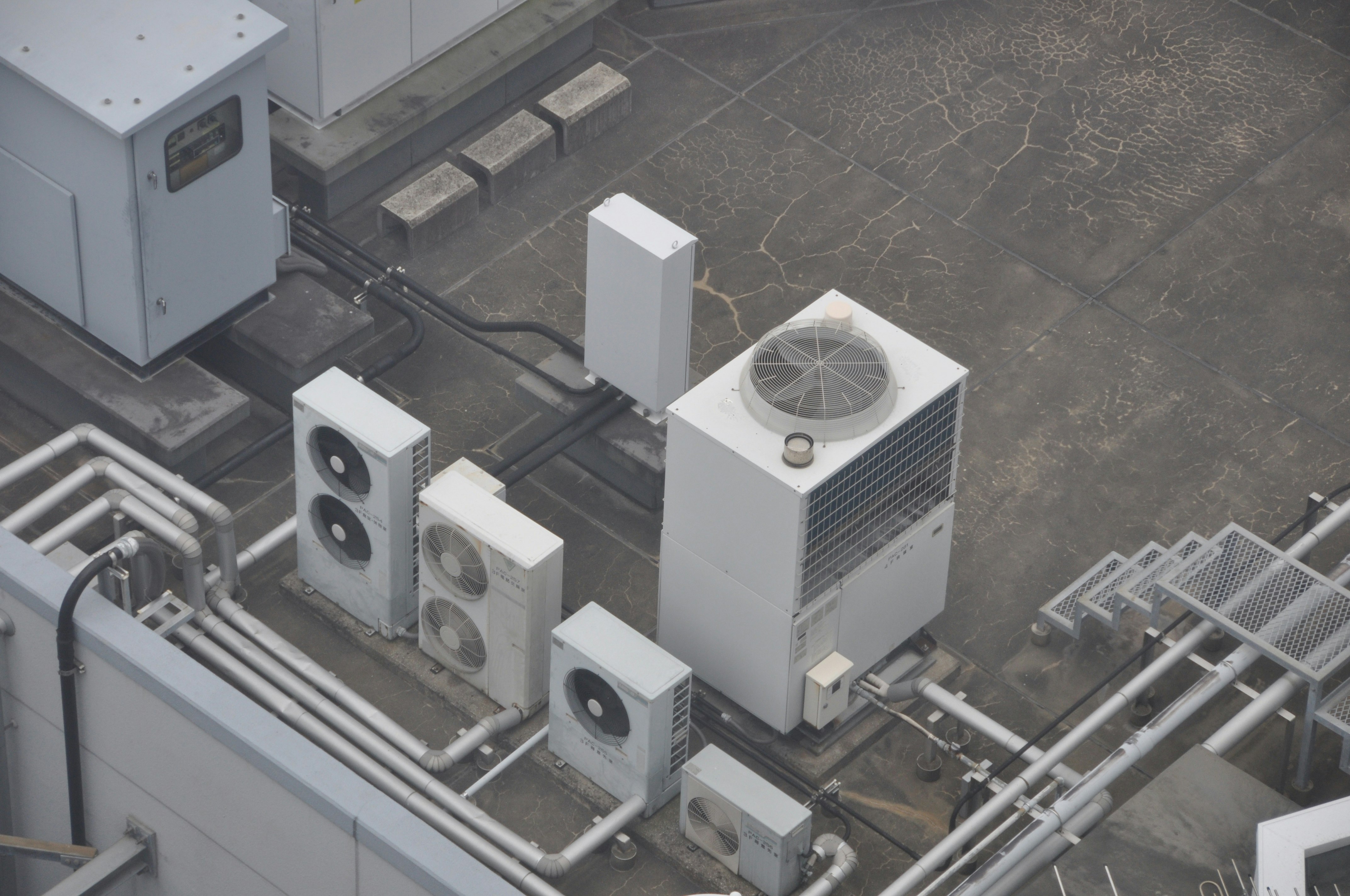 屋上の空調・換気設備と配管のある機械室