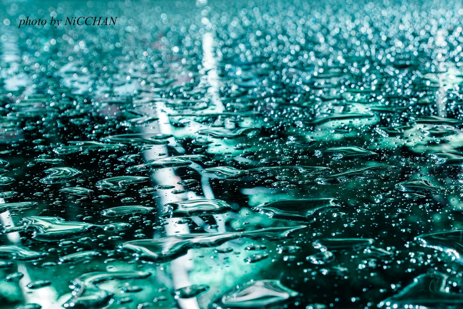 水滴が付いた青緑色の表面のクローズアップ