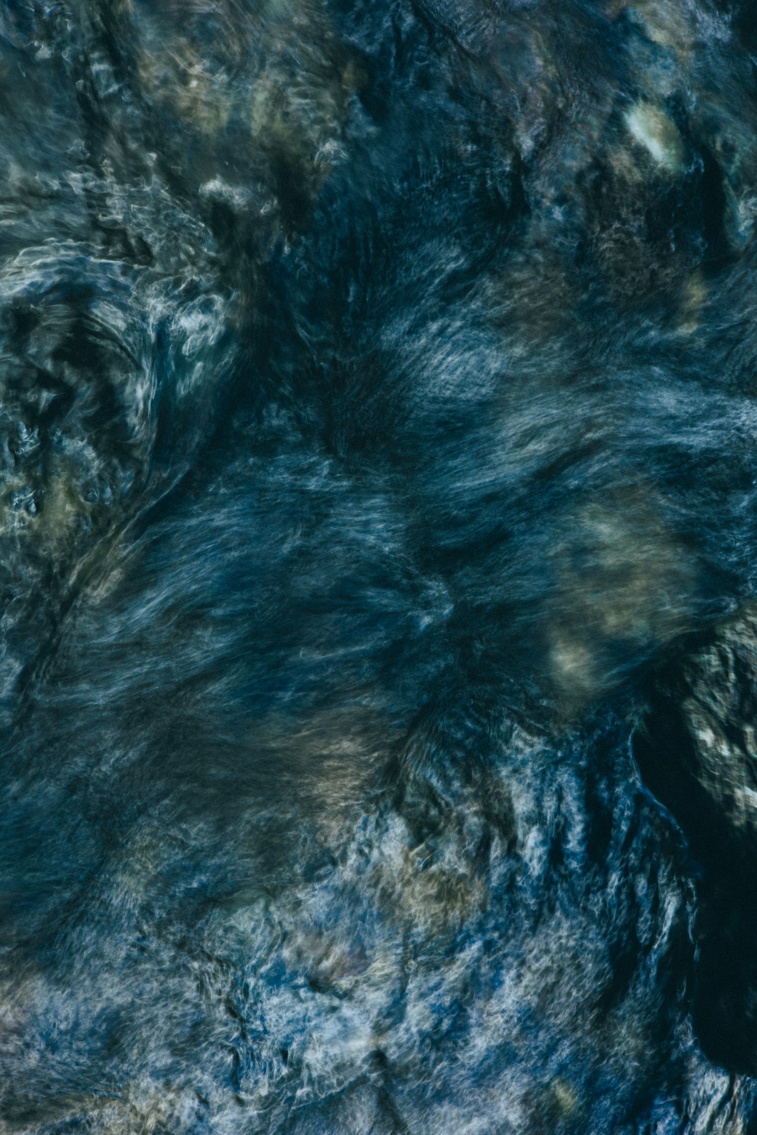 Surface d'eau texturée de couleur bleu foncé avec des motifs tourbillonnants