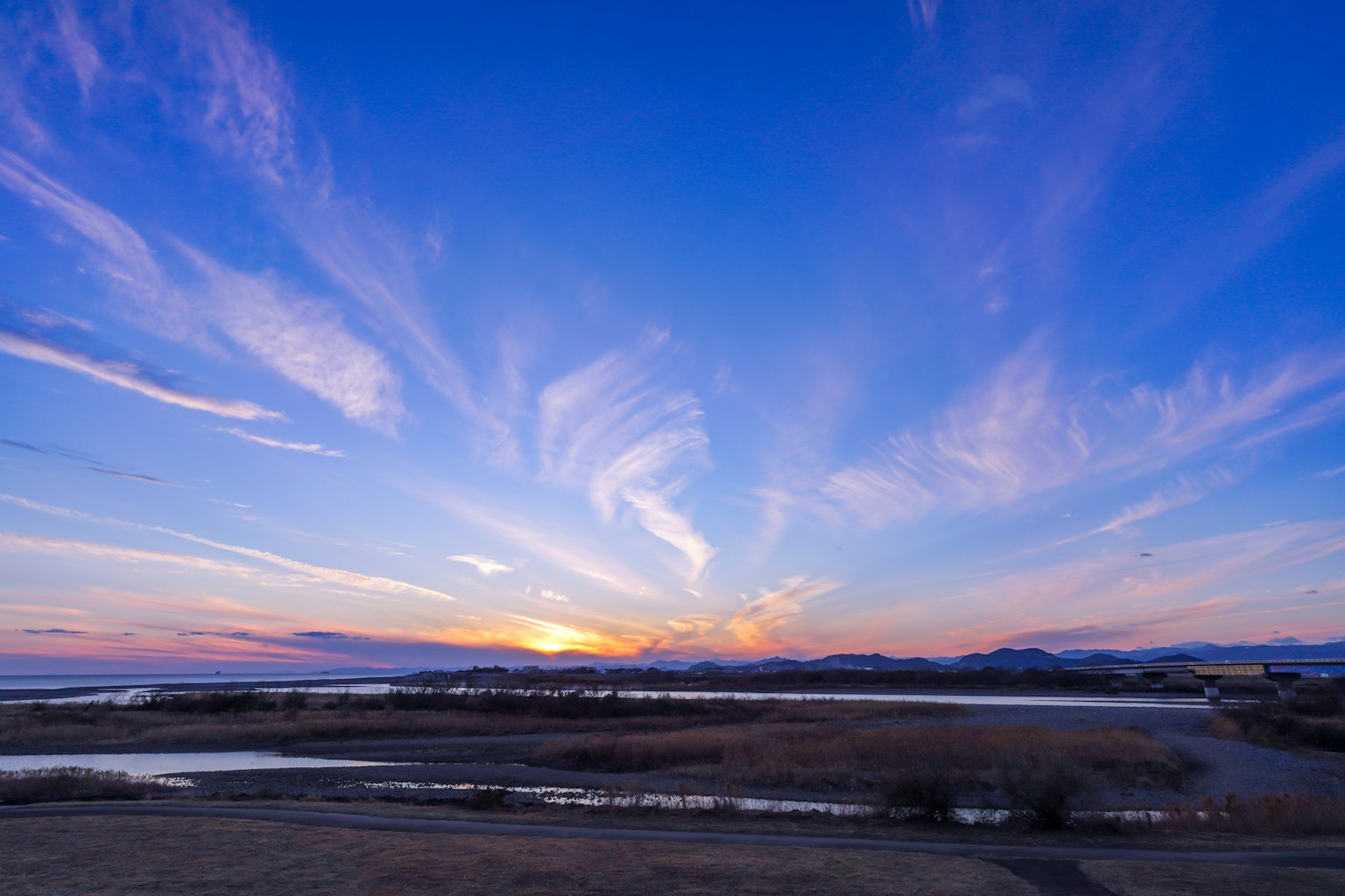 Scenic sunset view with vibrant blue sky and wispy clouds