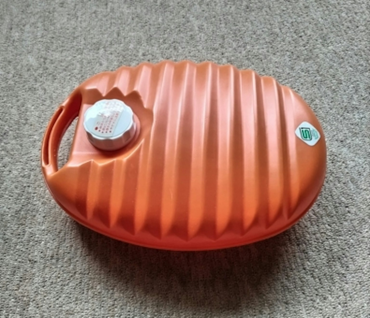 Bottiglia dell'acqua calda arancione con un design rigato