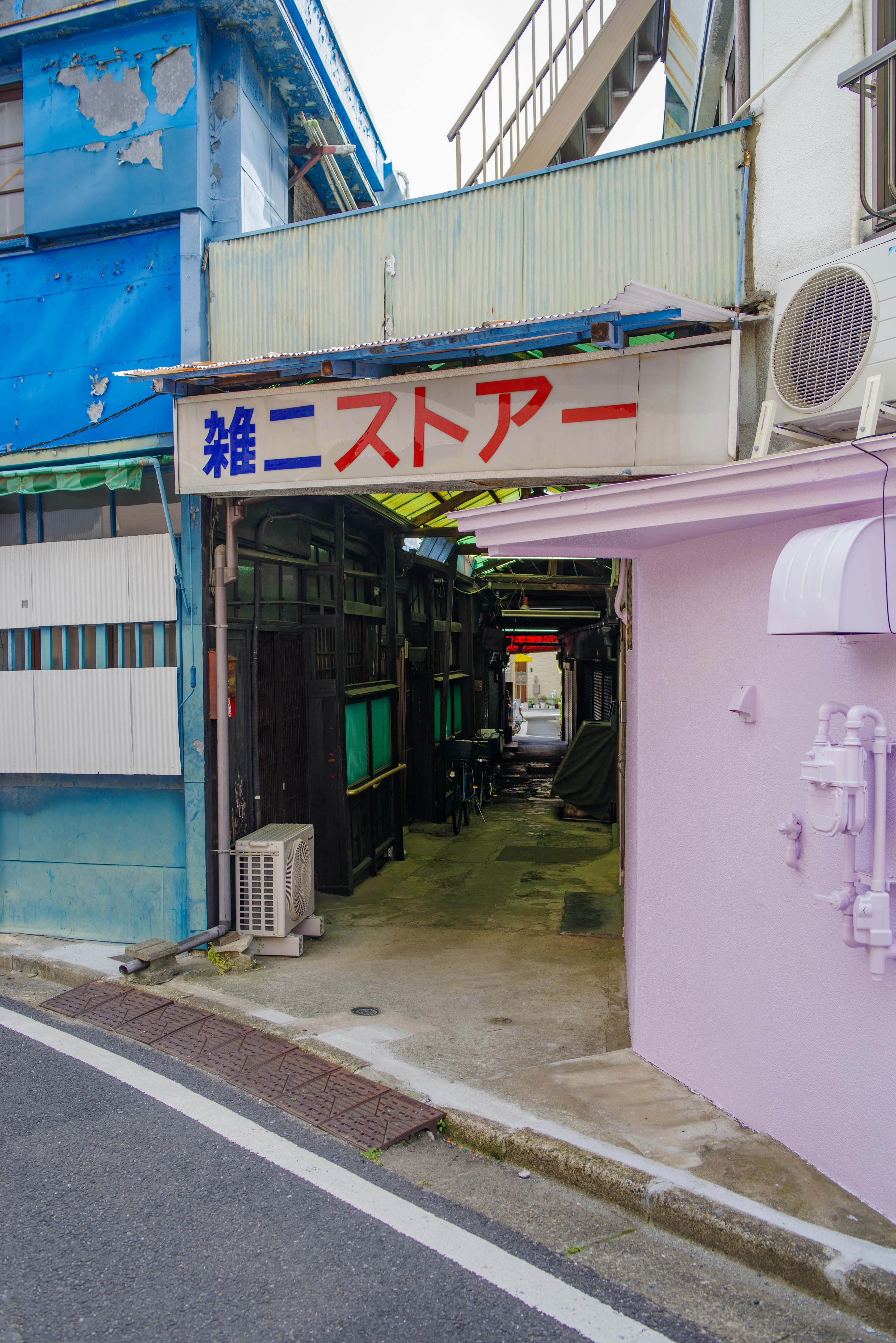 狹窄巷弄裡雜貨店的招牌與店鋪陳列