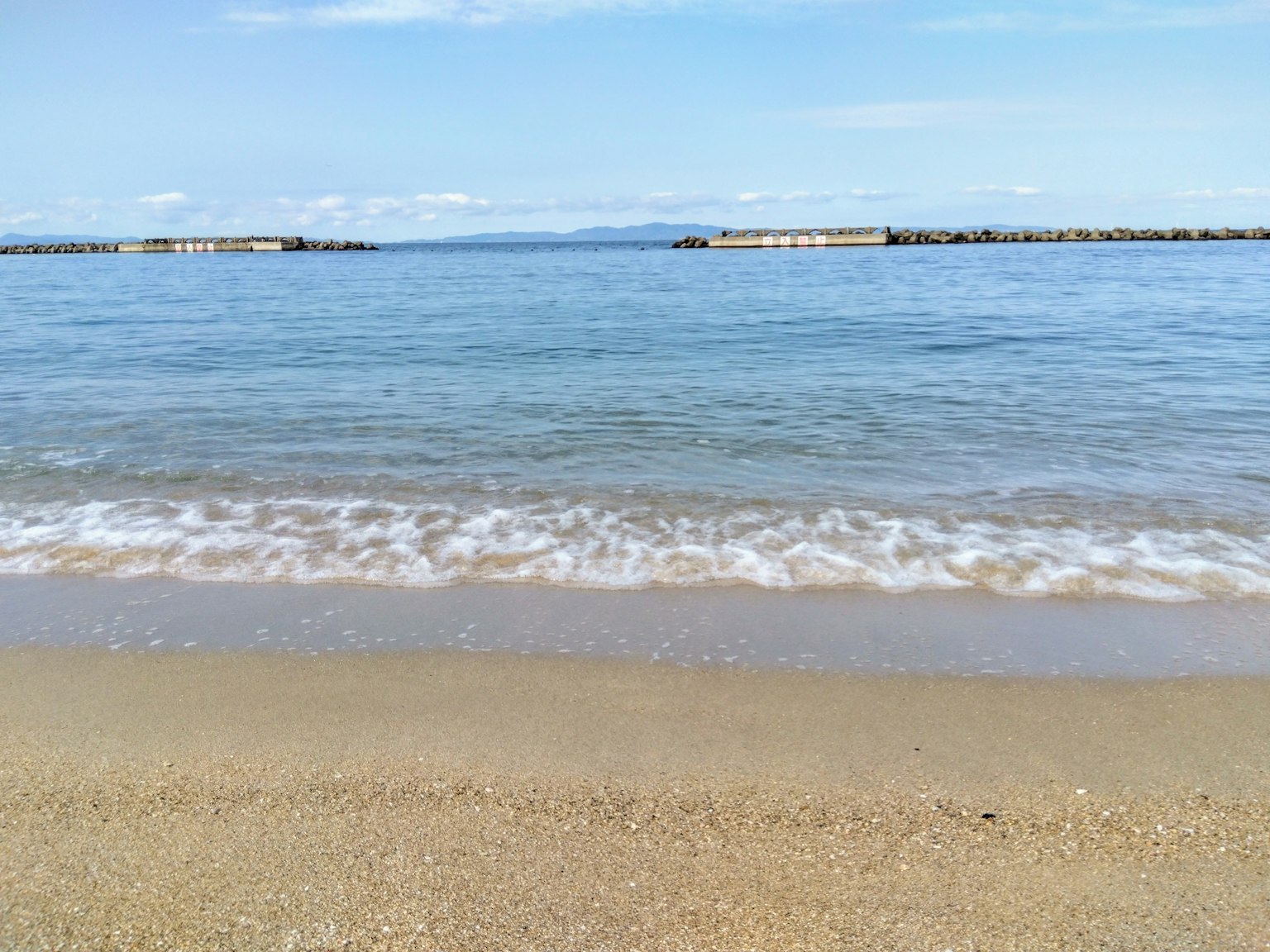 寧靜的海灘景觀，波浪平緩，藍色海洋