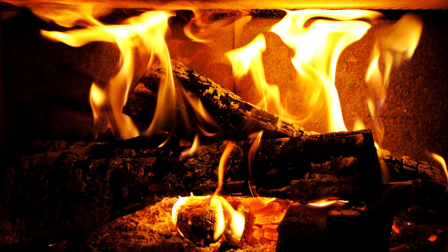 Fiamme che danzano su tronchi ardenti in un camino