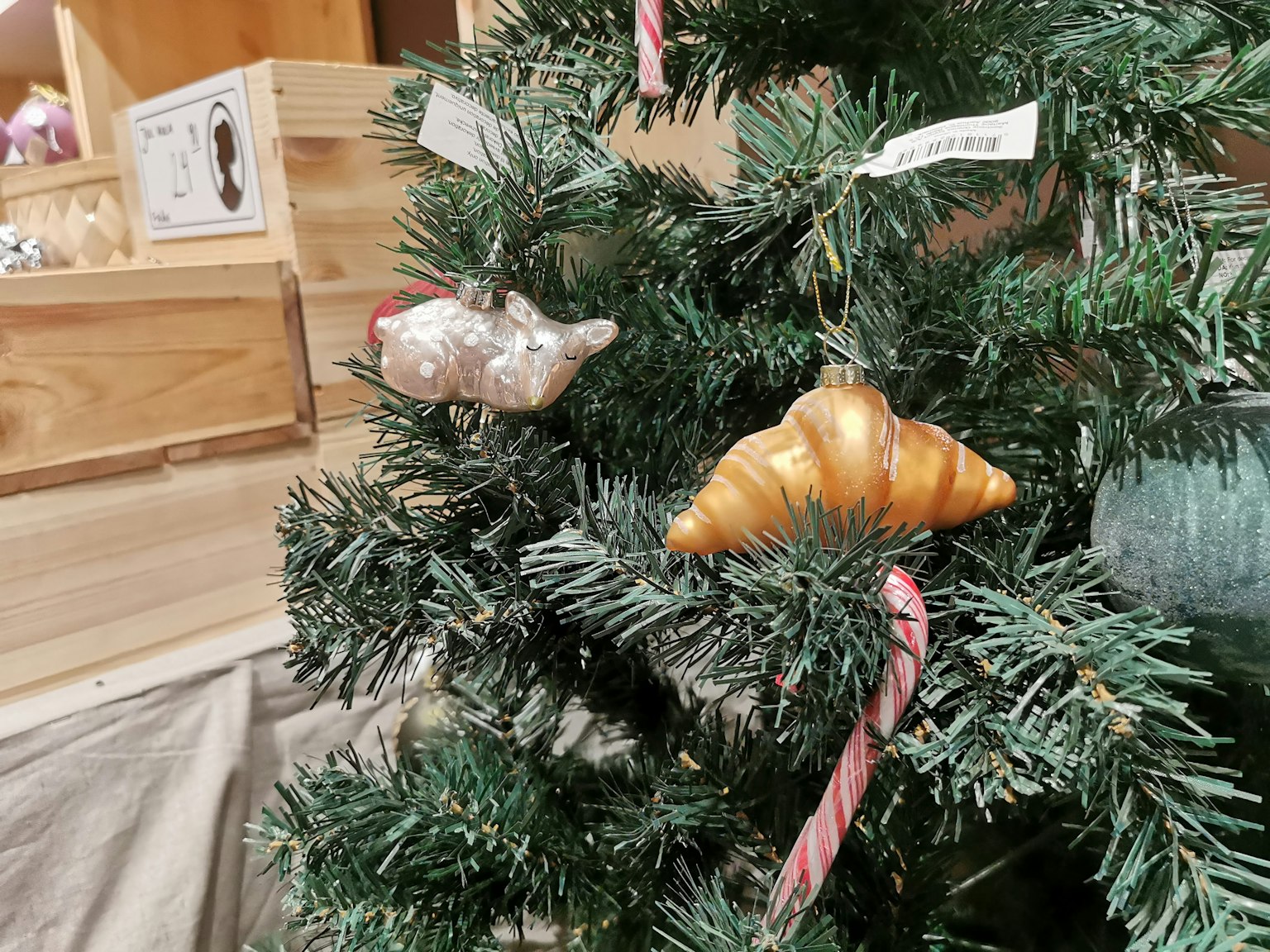 Croissant and shell ornaments hanging on a Christmas tree