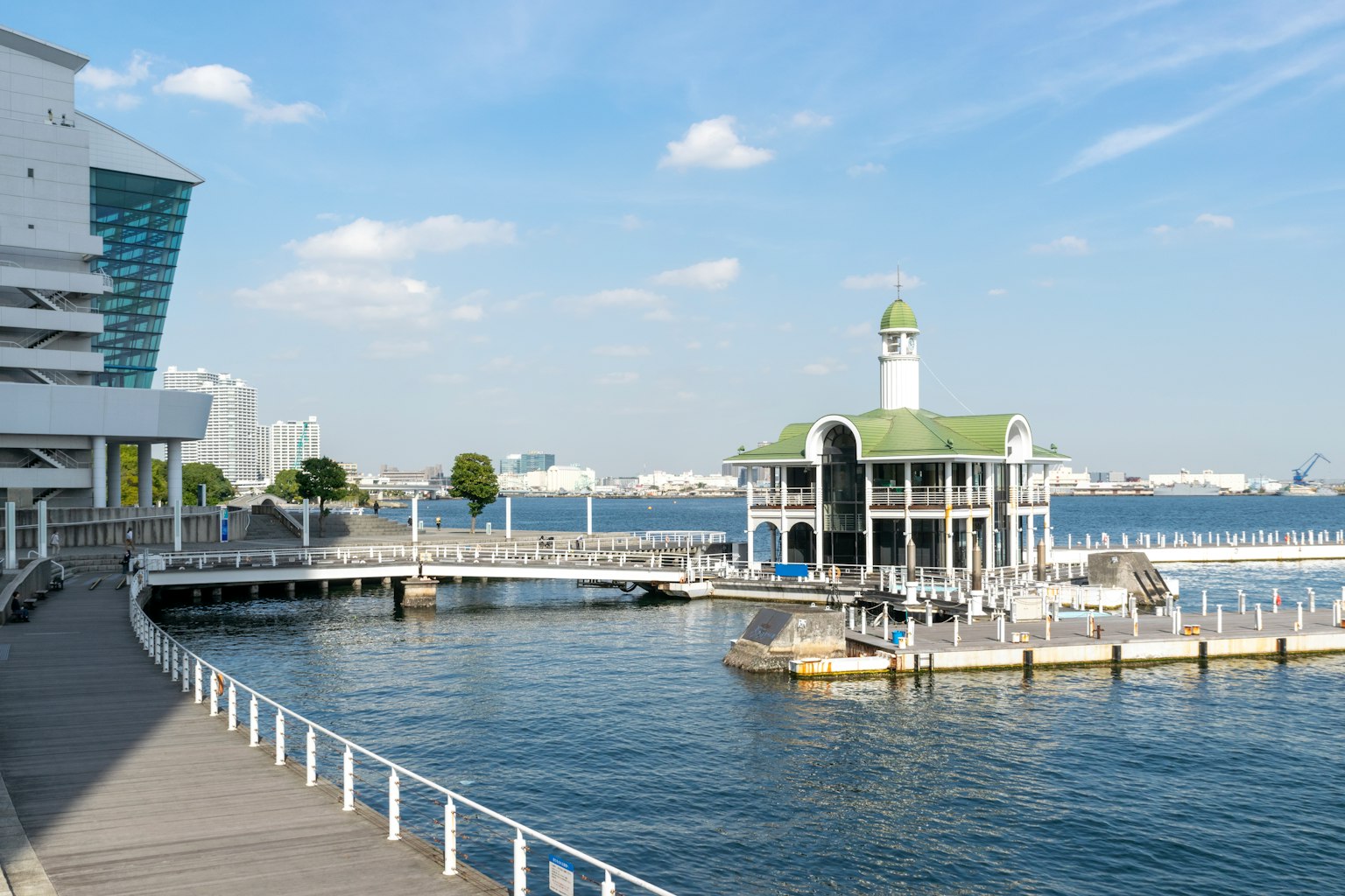 Scenic waterfront view featuring a white building with a green roof and a tower