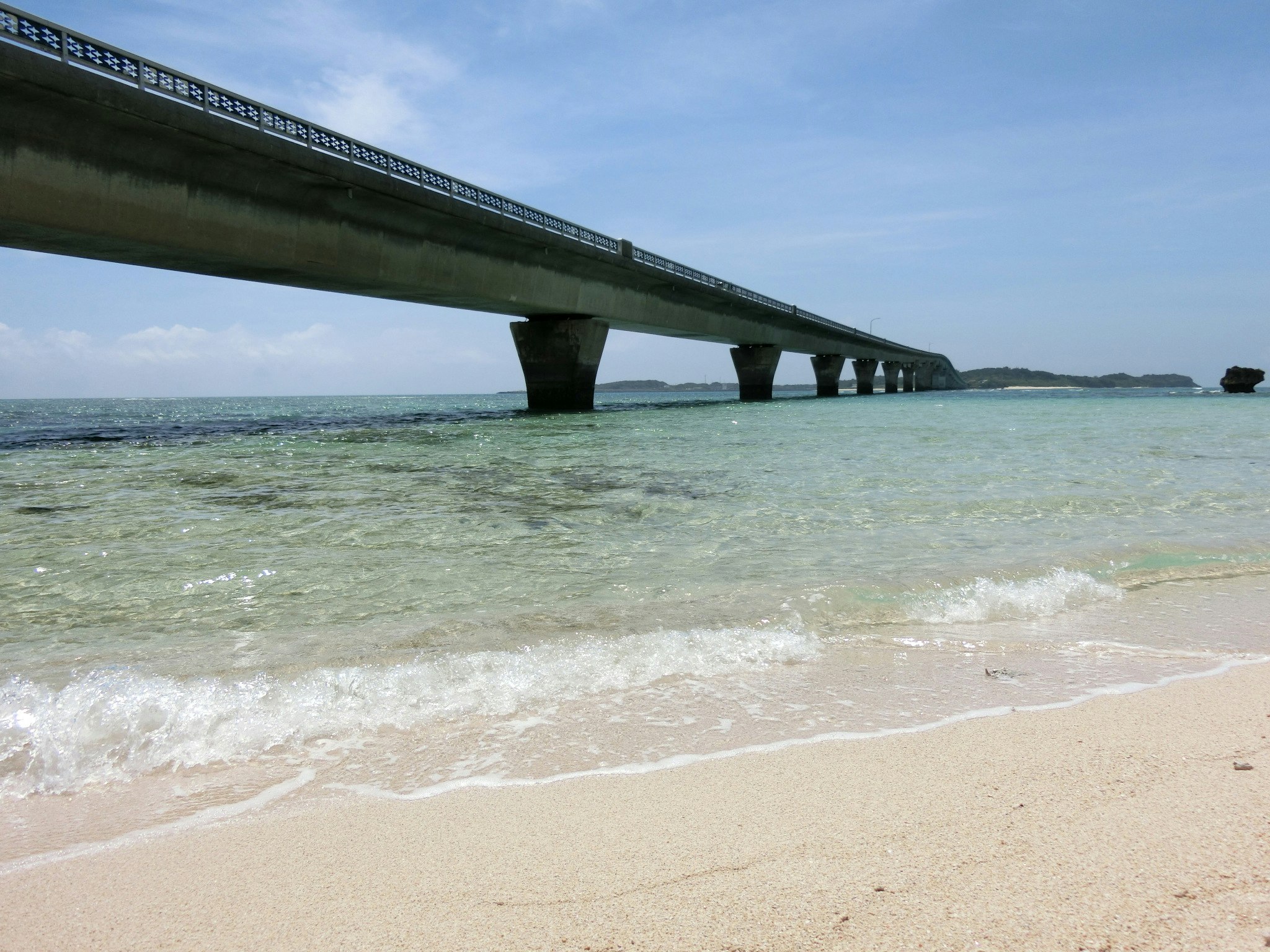 伊良部大橋を望む砂浜と青い海の海岸風景