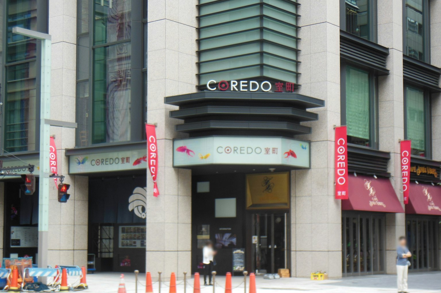 COREDO日本桥的外观有多个红色横幅和可见的交通信号灯