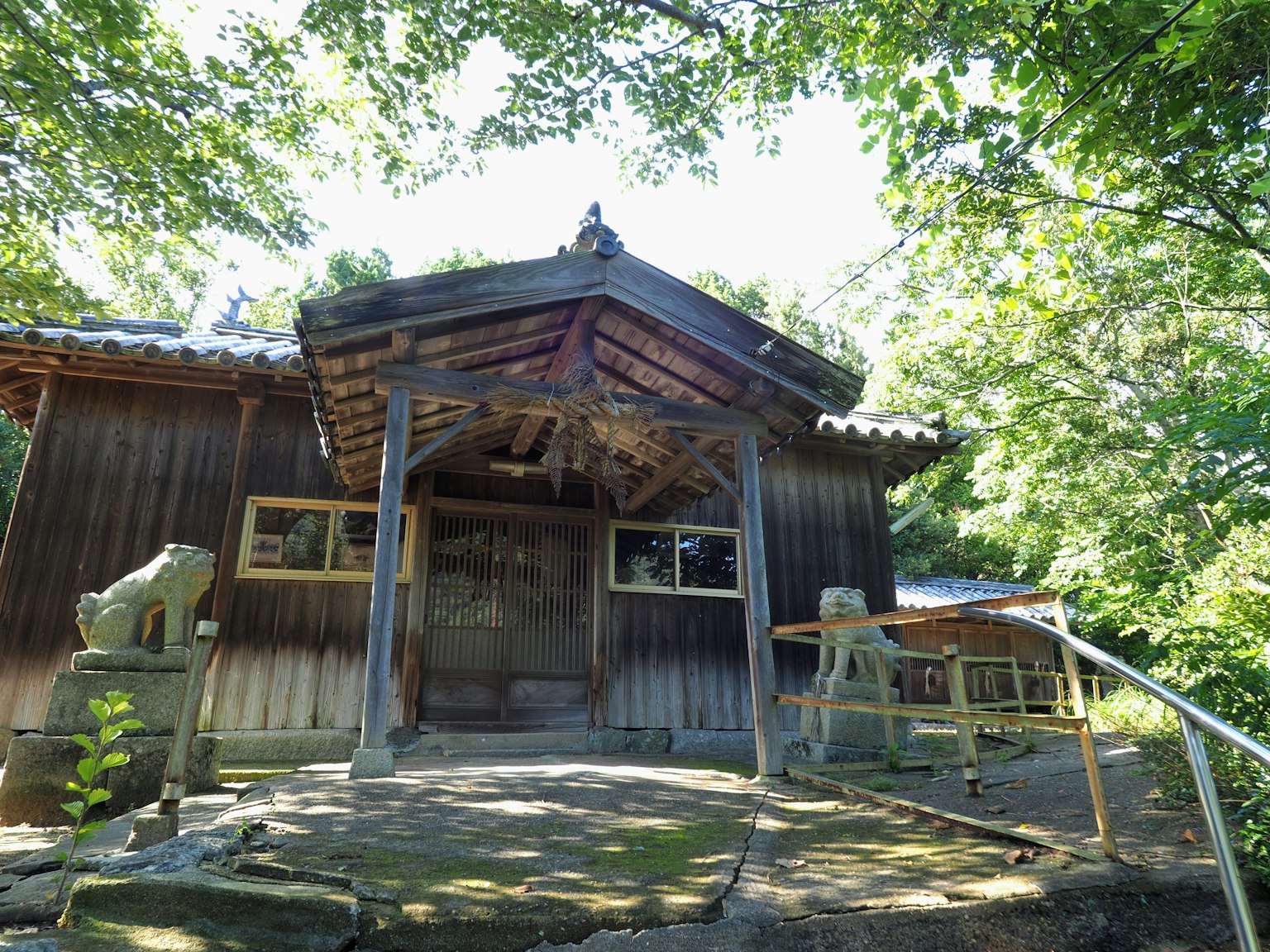 Außenansicht eines traditionellen japanischen Holzhauses umgeben von üppigem Grün