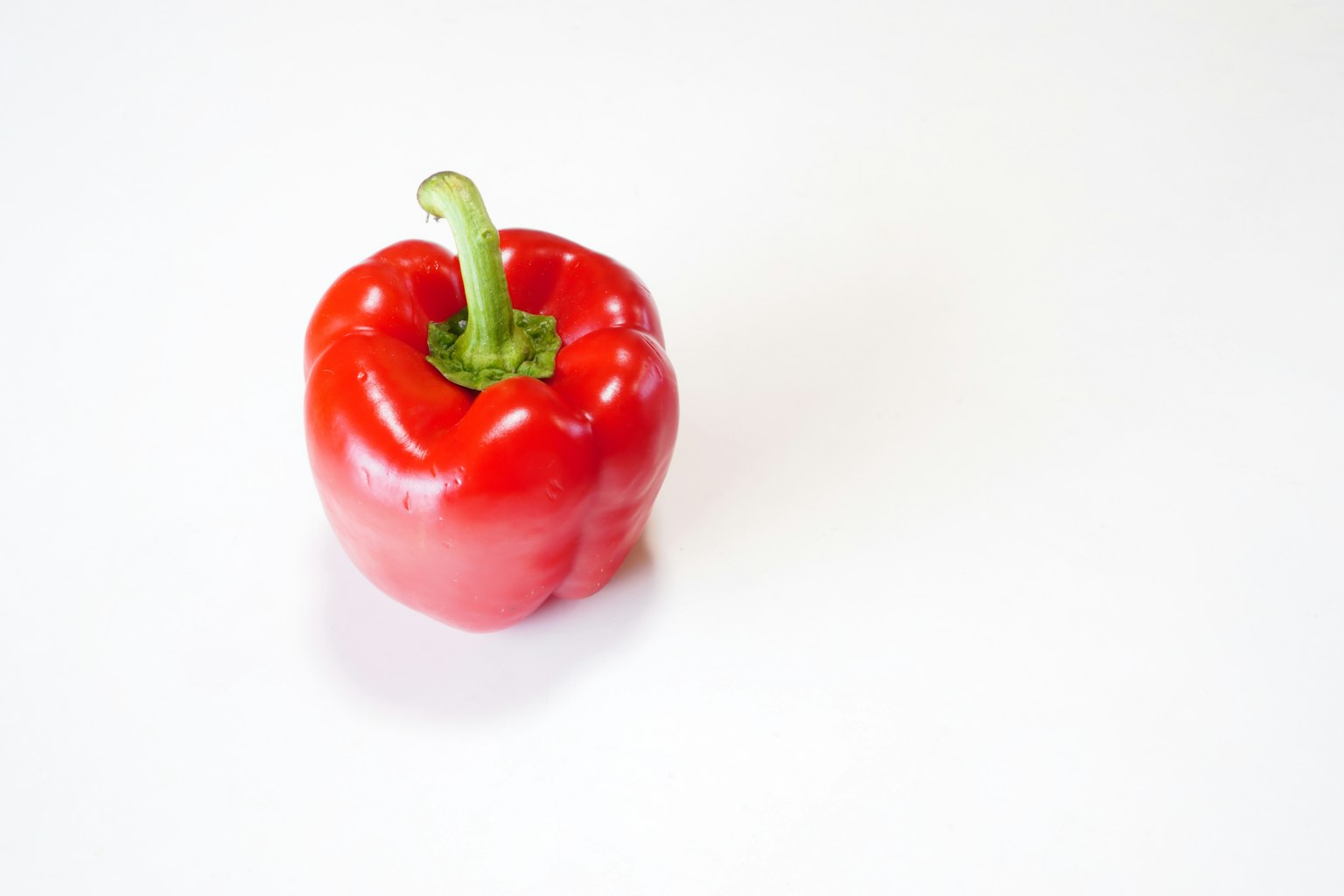 Un peperone rosso posato su uno sfondo bianco