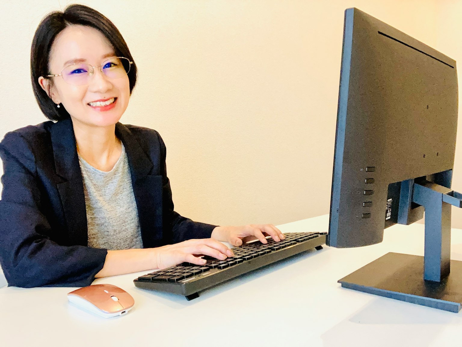 Una donna sorridente che lavora al computer in un ambiente d'ufficio