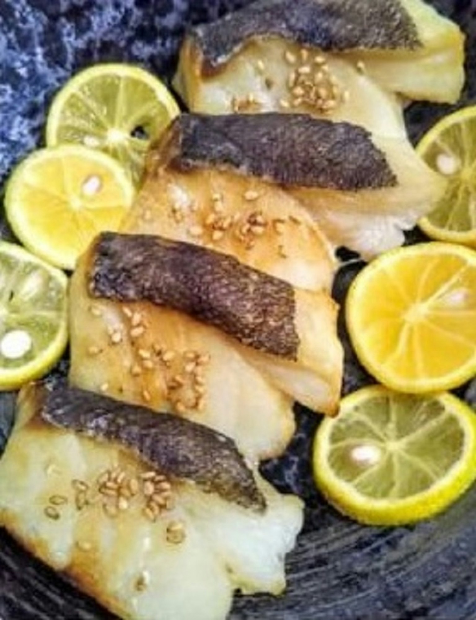 烤魚片搭配檸檬片和芝麻