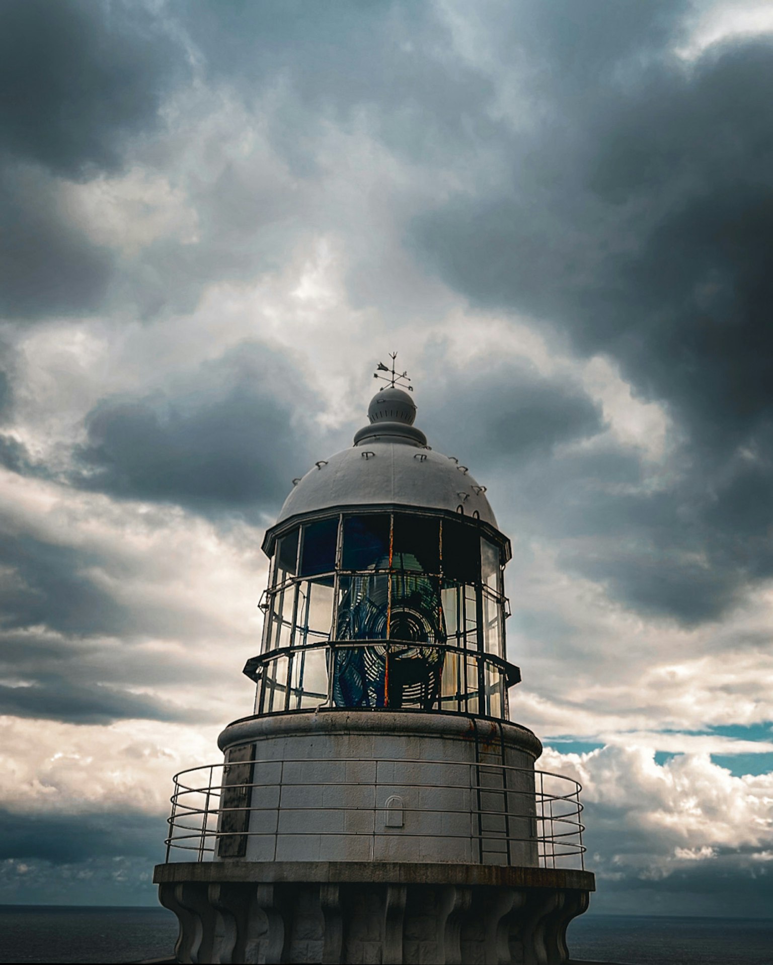 Ein Leuchtturm unter einem dramatischen, bewölkten Himmel