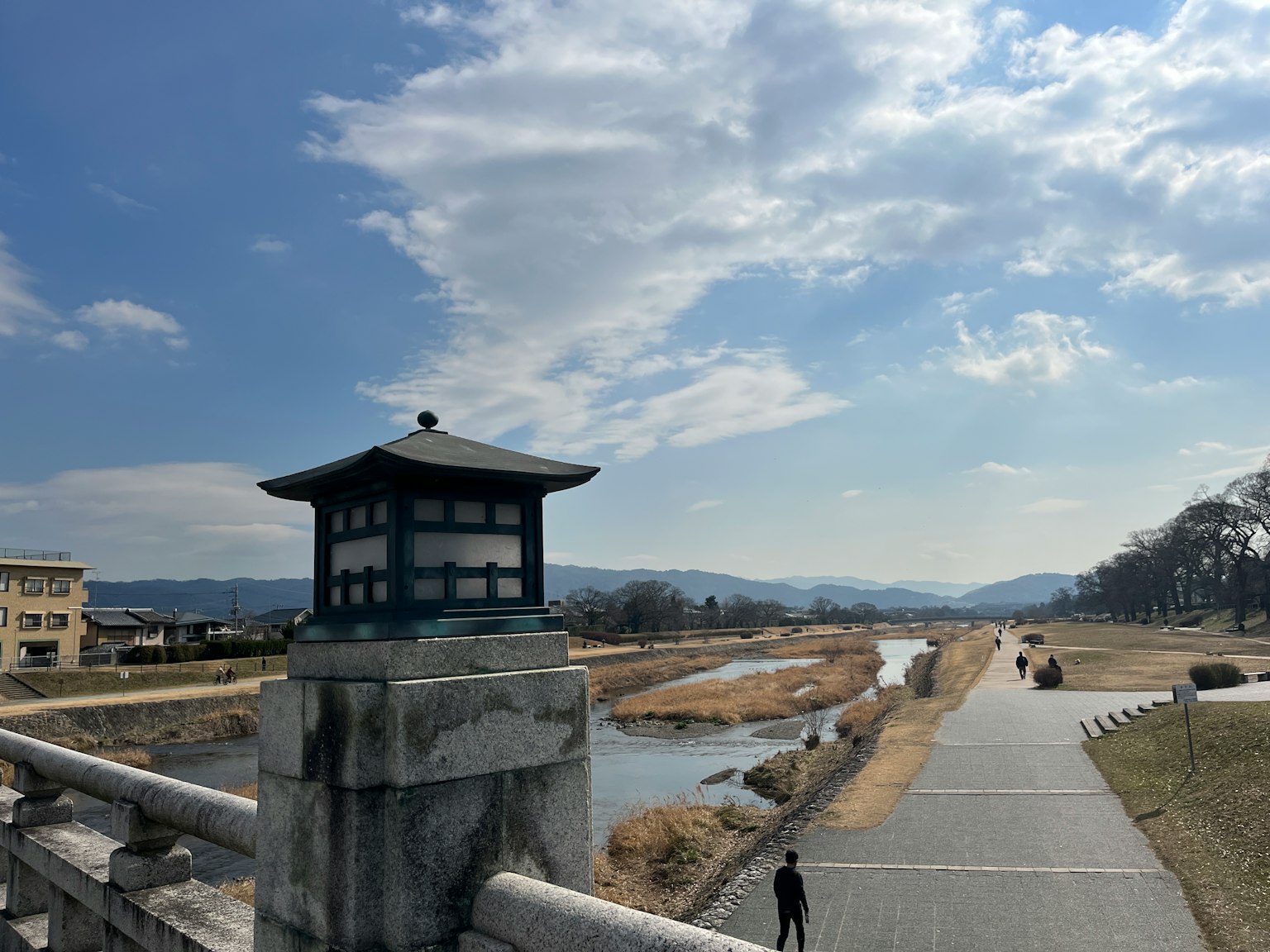 蓝天之下的河流和桥的风景 桥上的灯笼和远处的山脉