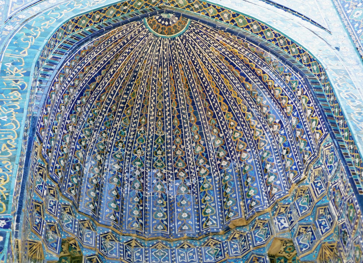 Decoración intrincada de la cúpula de una mezquita con azulejos azules y patrones geométricos