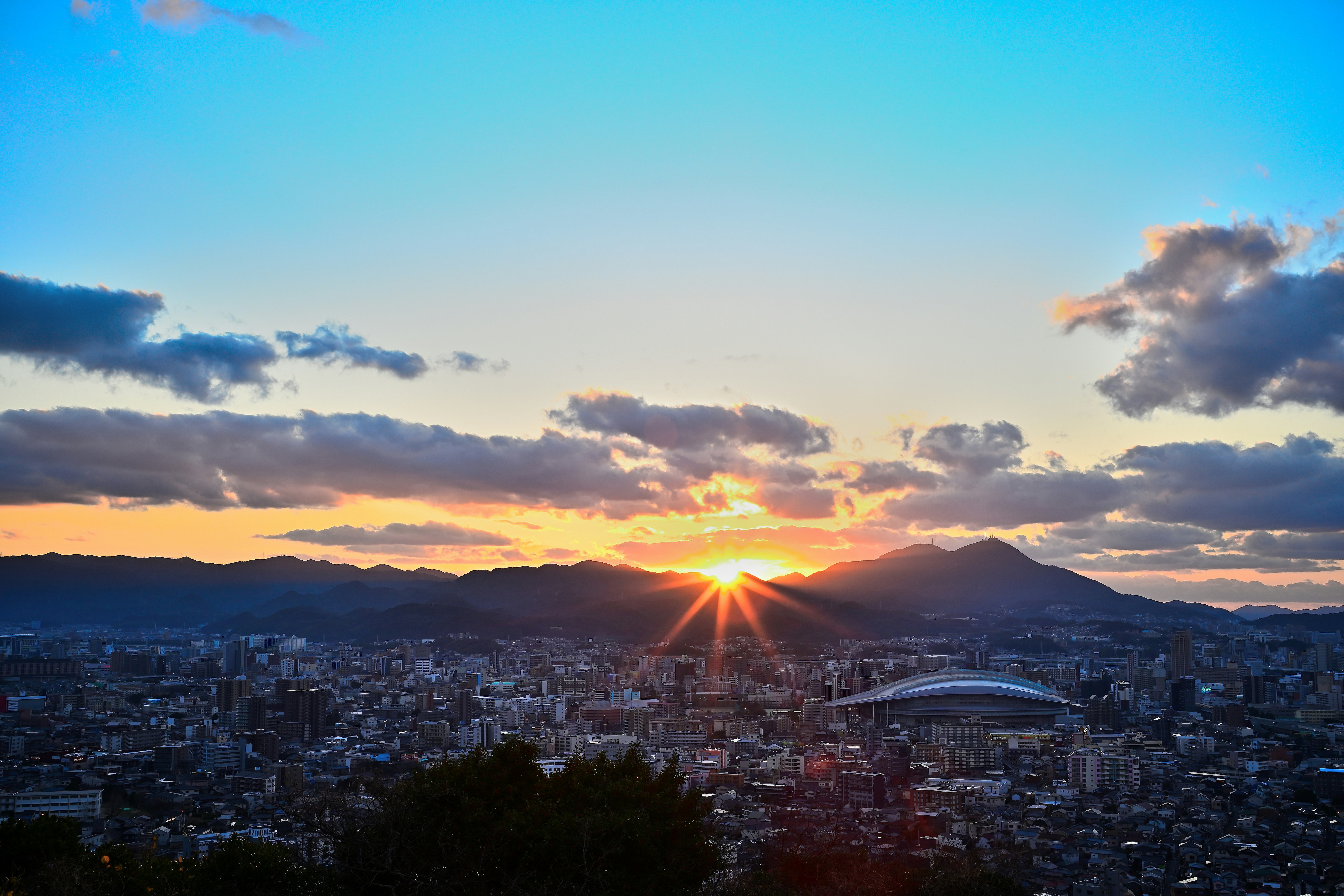 夕日に照らされる街並みと山並みのパノラマ