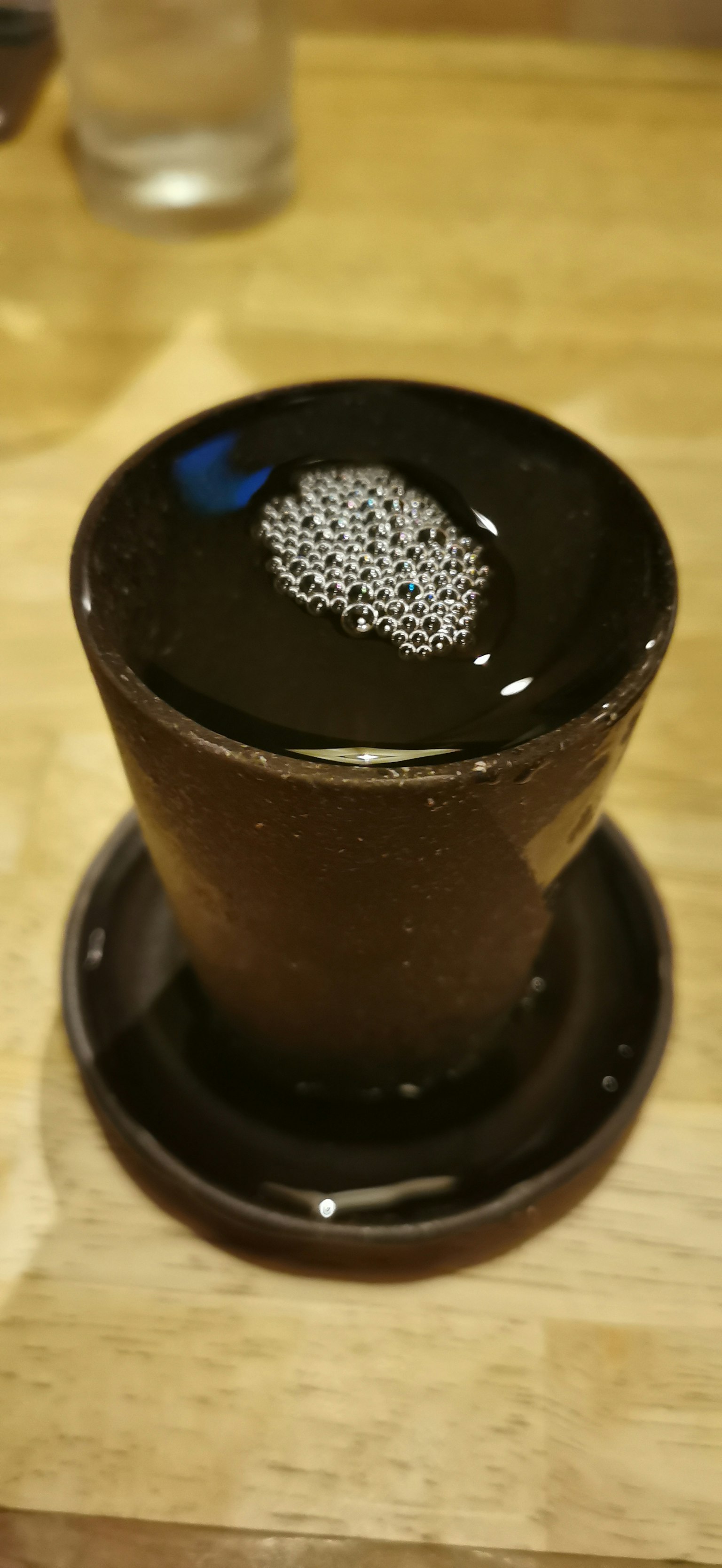 Motivo unico sulla superficie dell'acqua in una tazza di ceramica nera