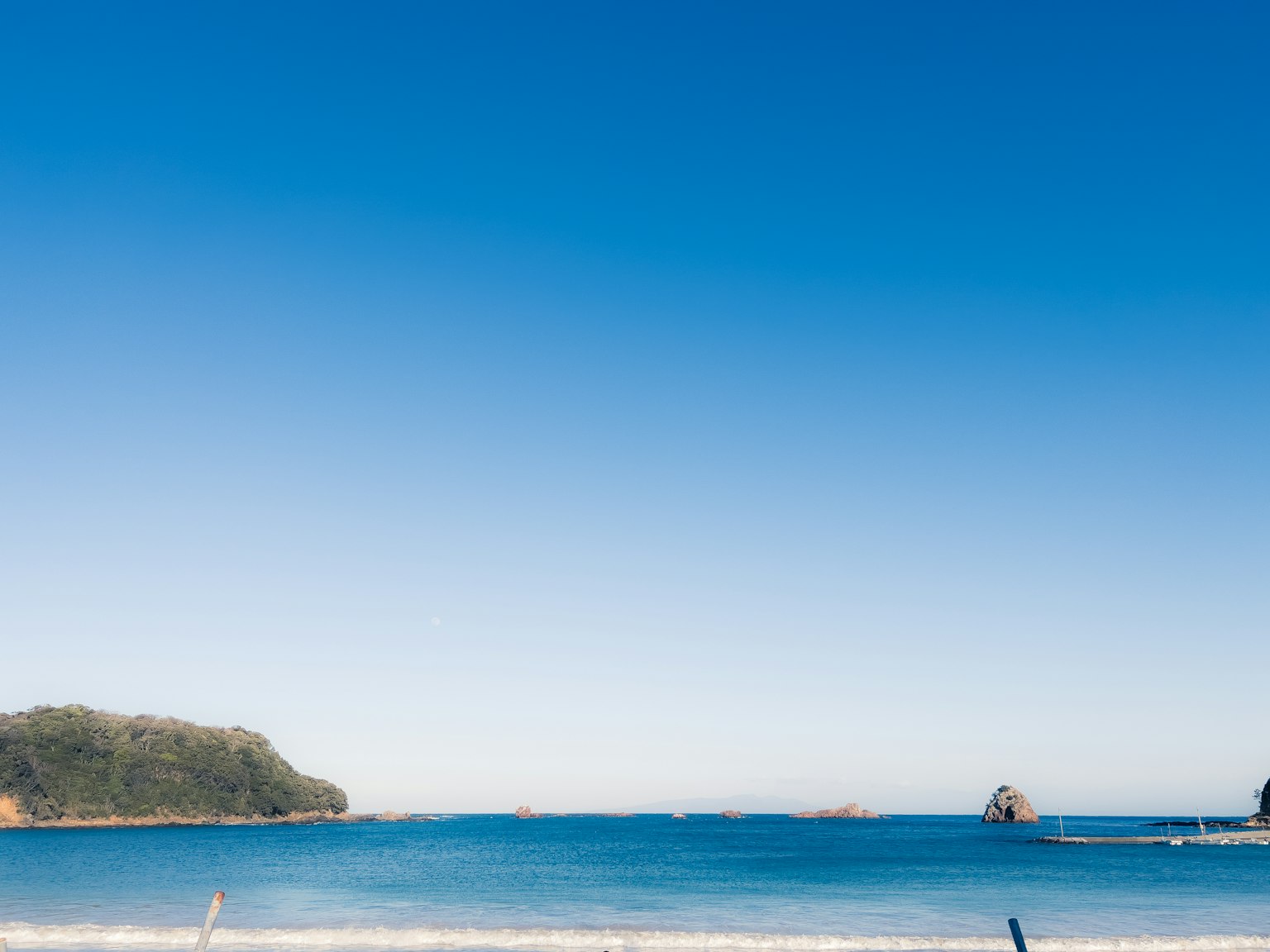Pemandangan pantai yang indah dengan lautan biru dan langit cerah