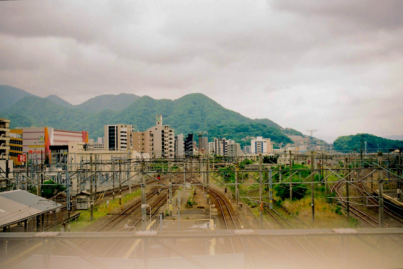 风景秀丽的铁路景观，背景有山脉和城市天际线