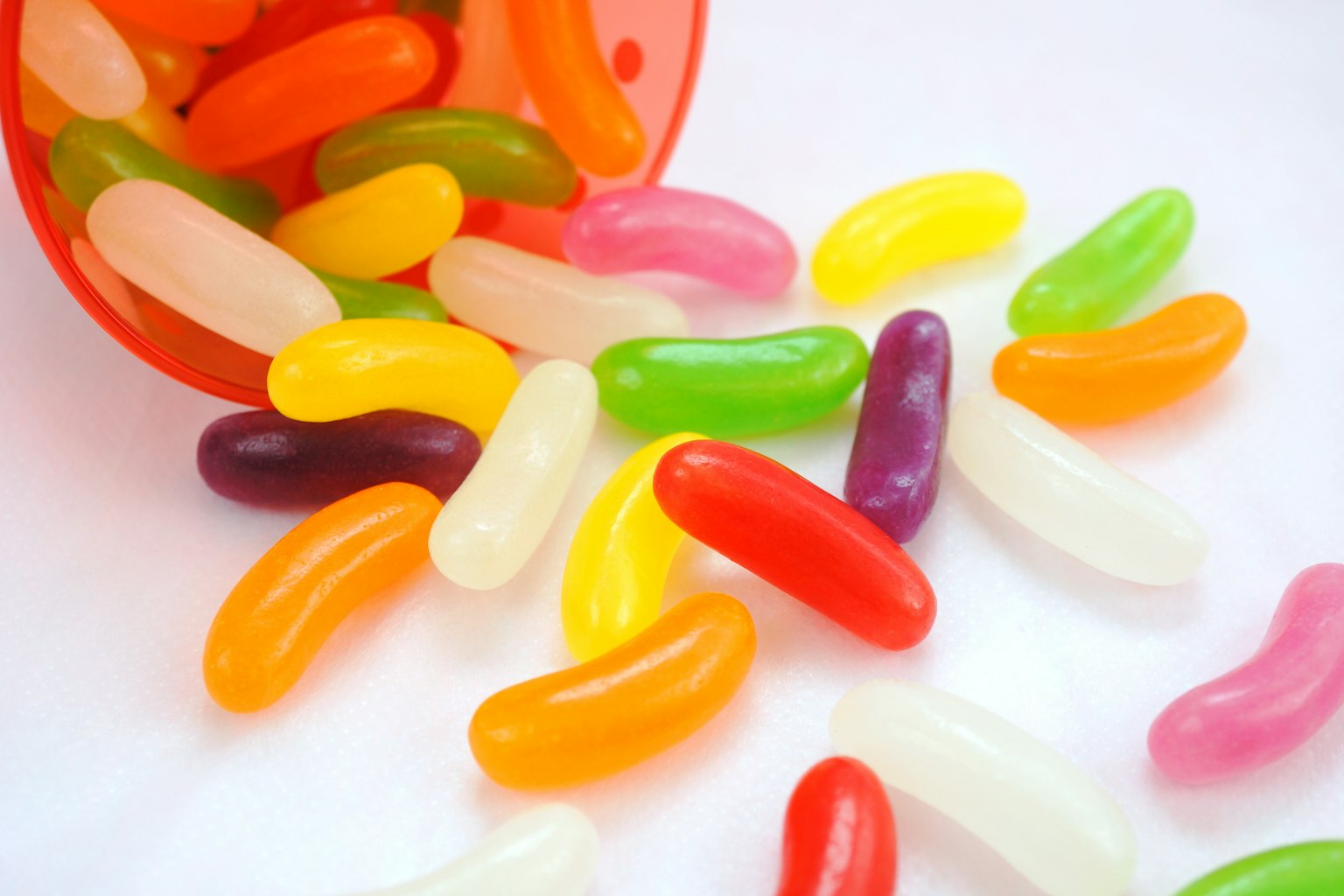 彩色果冻豆散落在白色表面上
