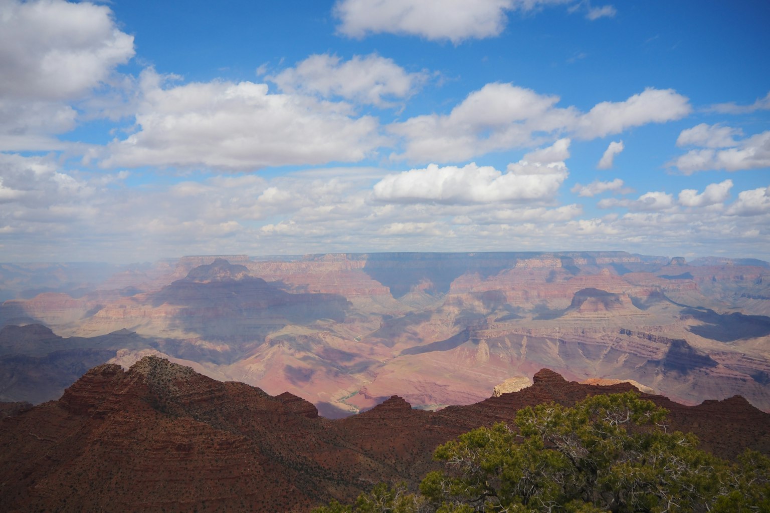 Pemandangan luas Grand Canyon dengan langit biru dan awan