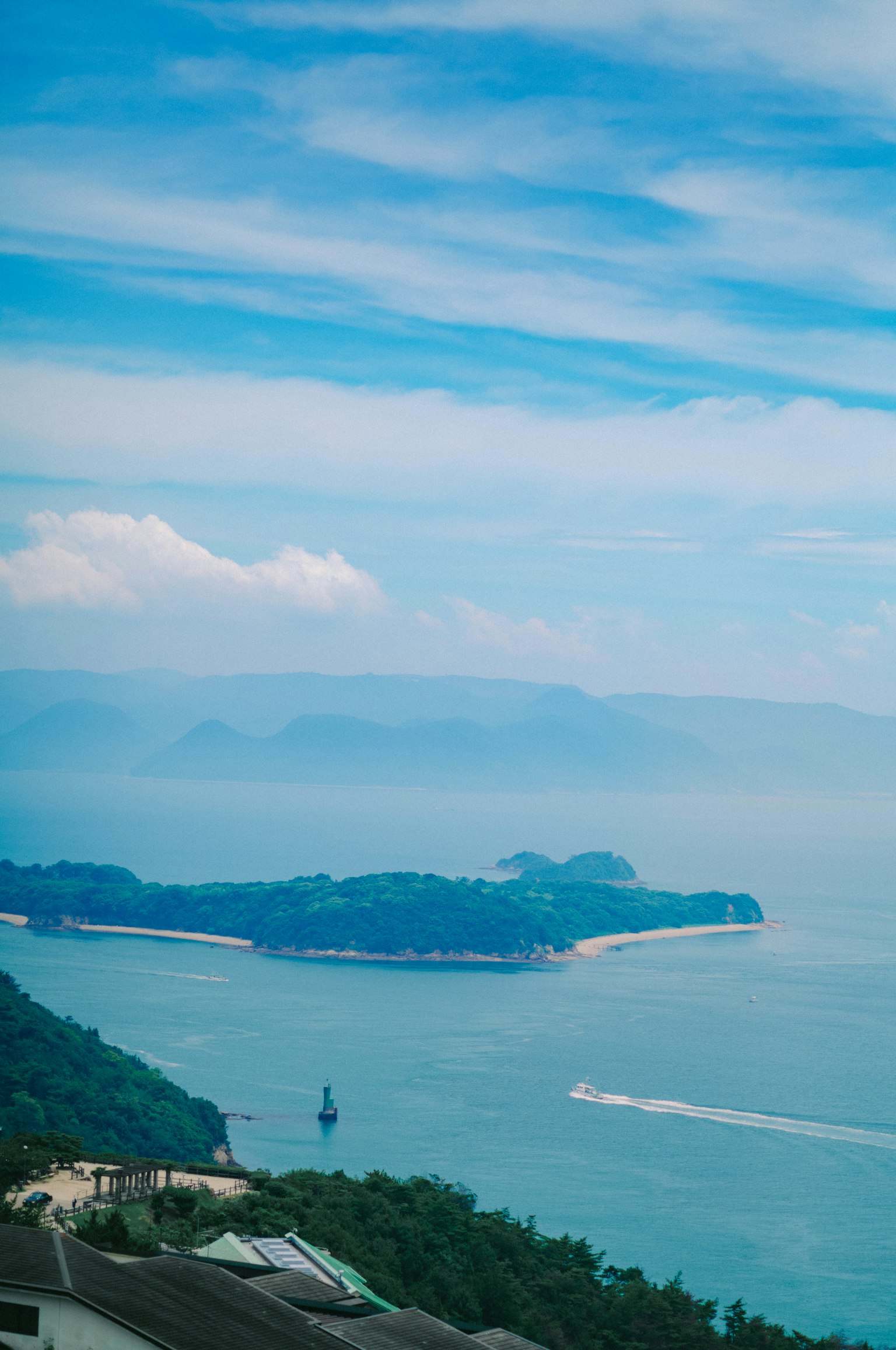 ทิวทัศน์ทะเลสีน้ำเงินและท้องฟ้าพร้อมเกาะและเมฆสีขาว