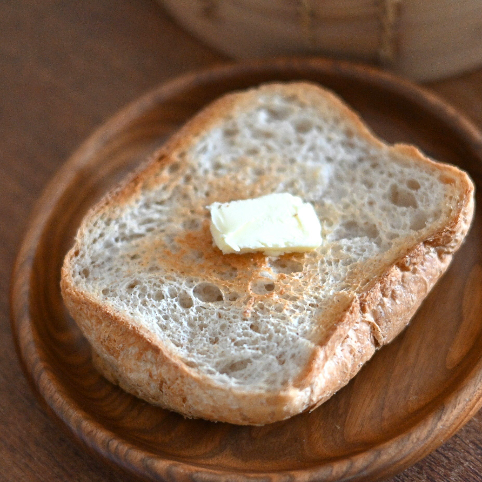 全粒粉の食パンにバターをのせた素朴な朝食