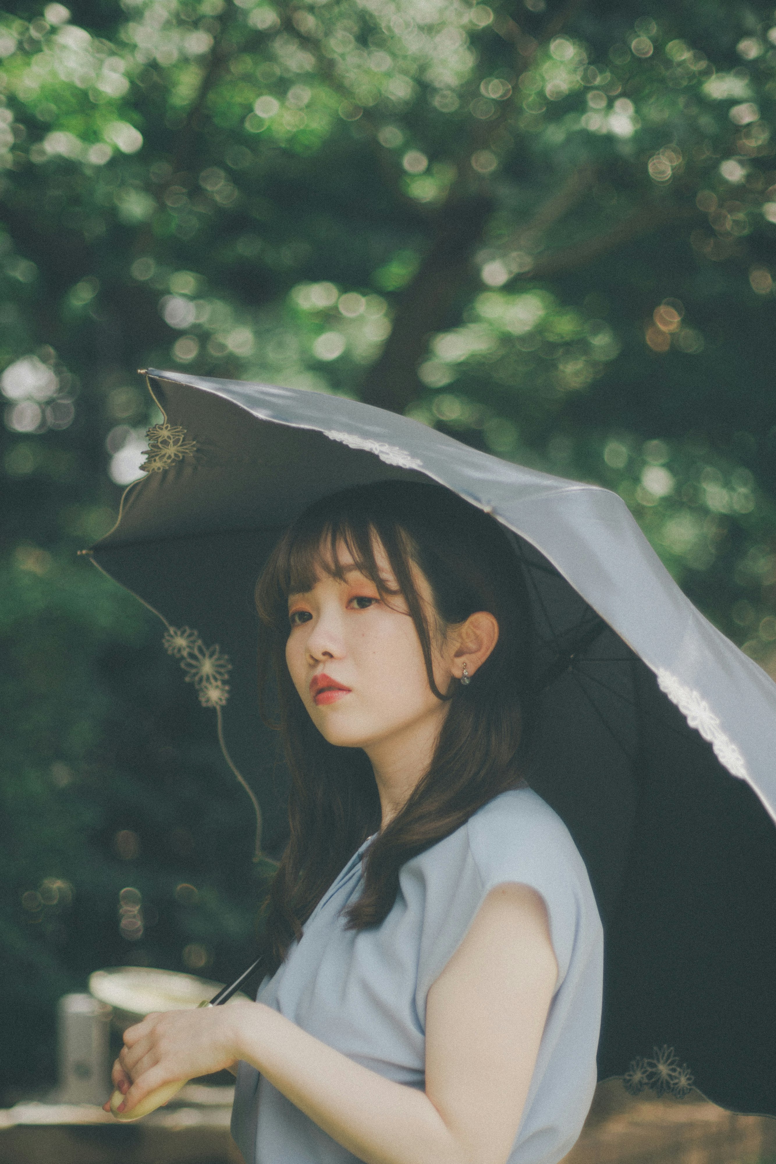 木陰で傘をさす女性の横顔