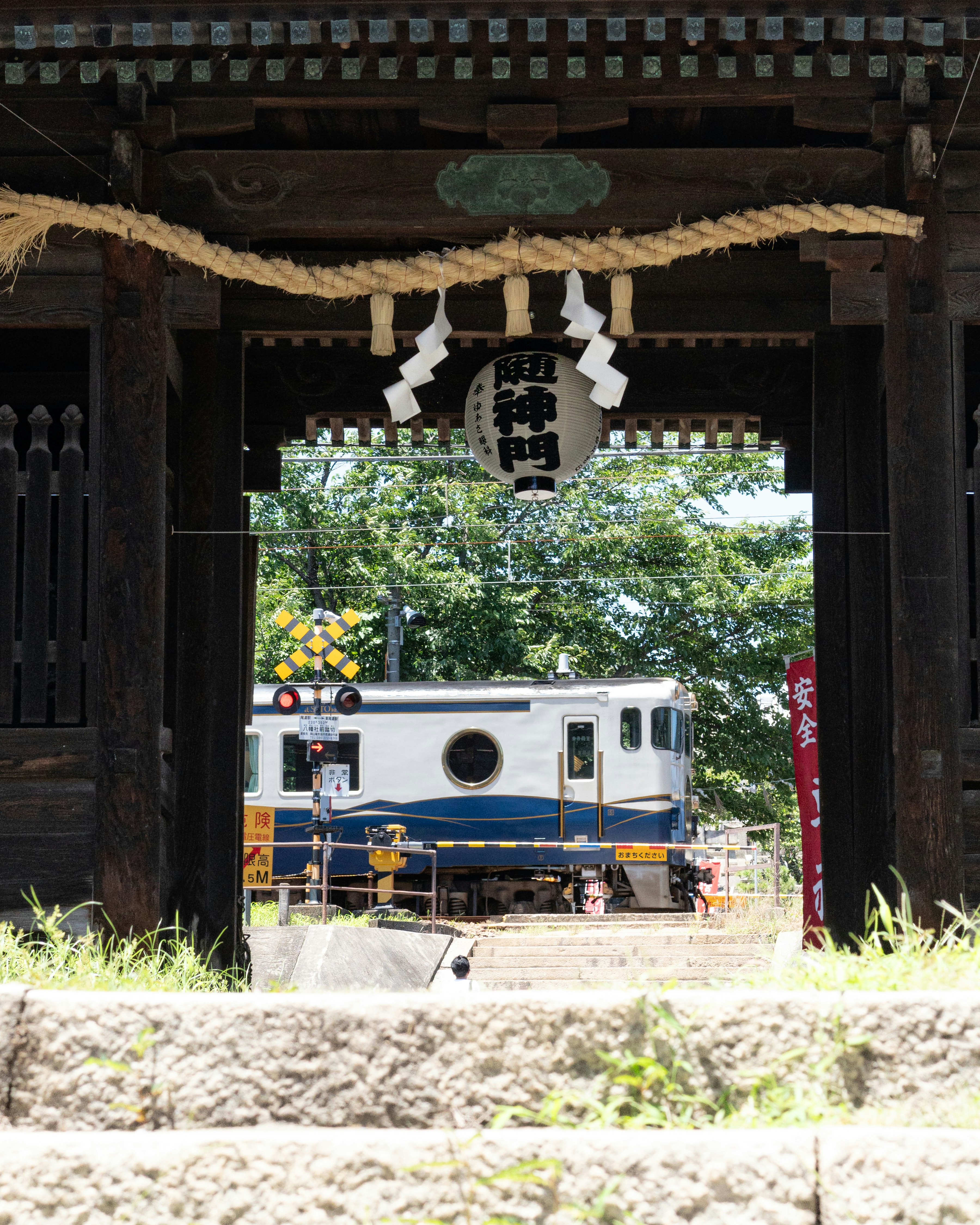 尾道の路地を抜ける鉄道車両のある風景