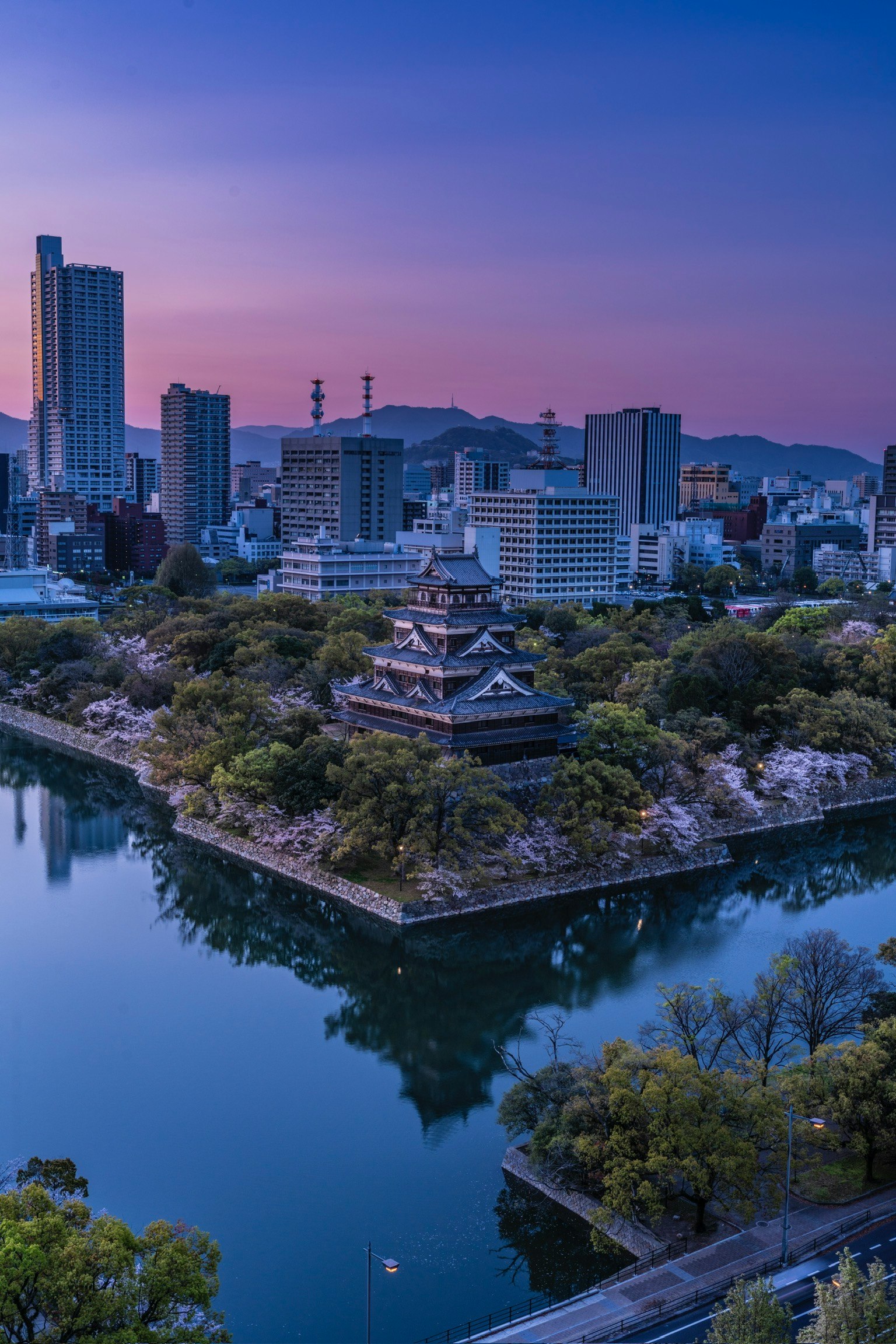 ทิวทัศน์ที่สวยงามของปราสาทโอซาก้าที่พลบค่ำกับเส้นขอบฟ้าในเมือง