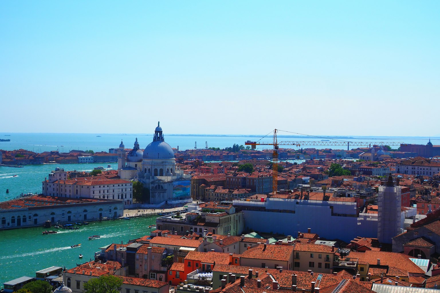 Schöner Blick auf Venedig mit roten Dächern und blauem Meer mit der Kuppel von San Giorgio Maggiore