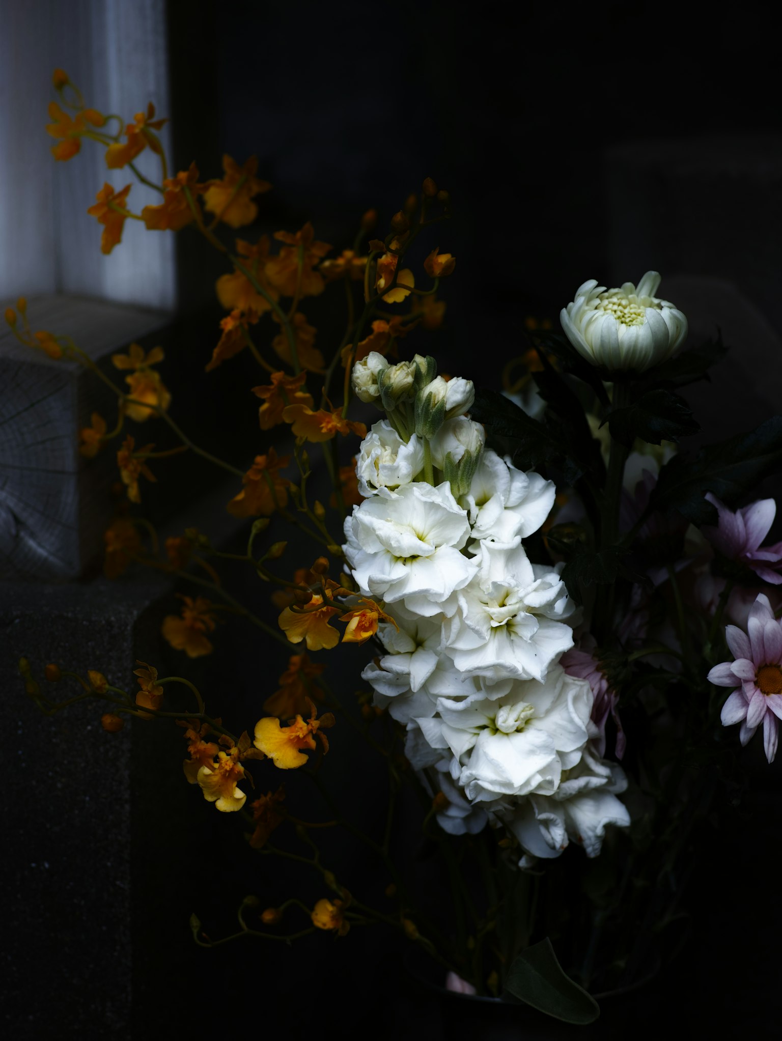 黑暗背景上的白色和黄色花束