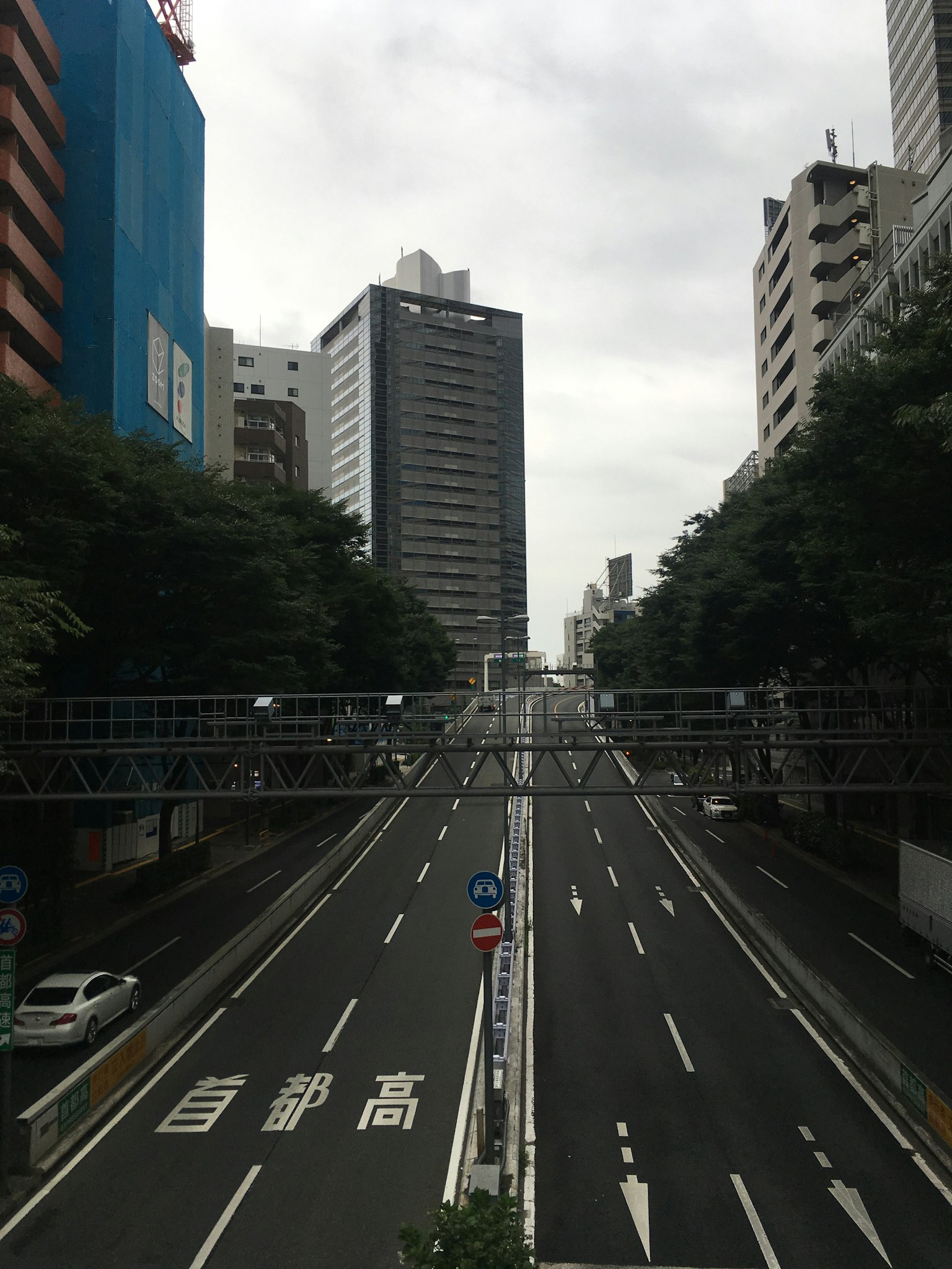 Una carretera tranquila flanqueada por altos edificios bajo un cielo nublado