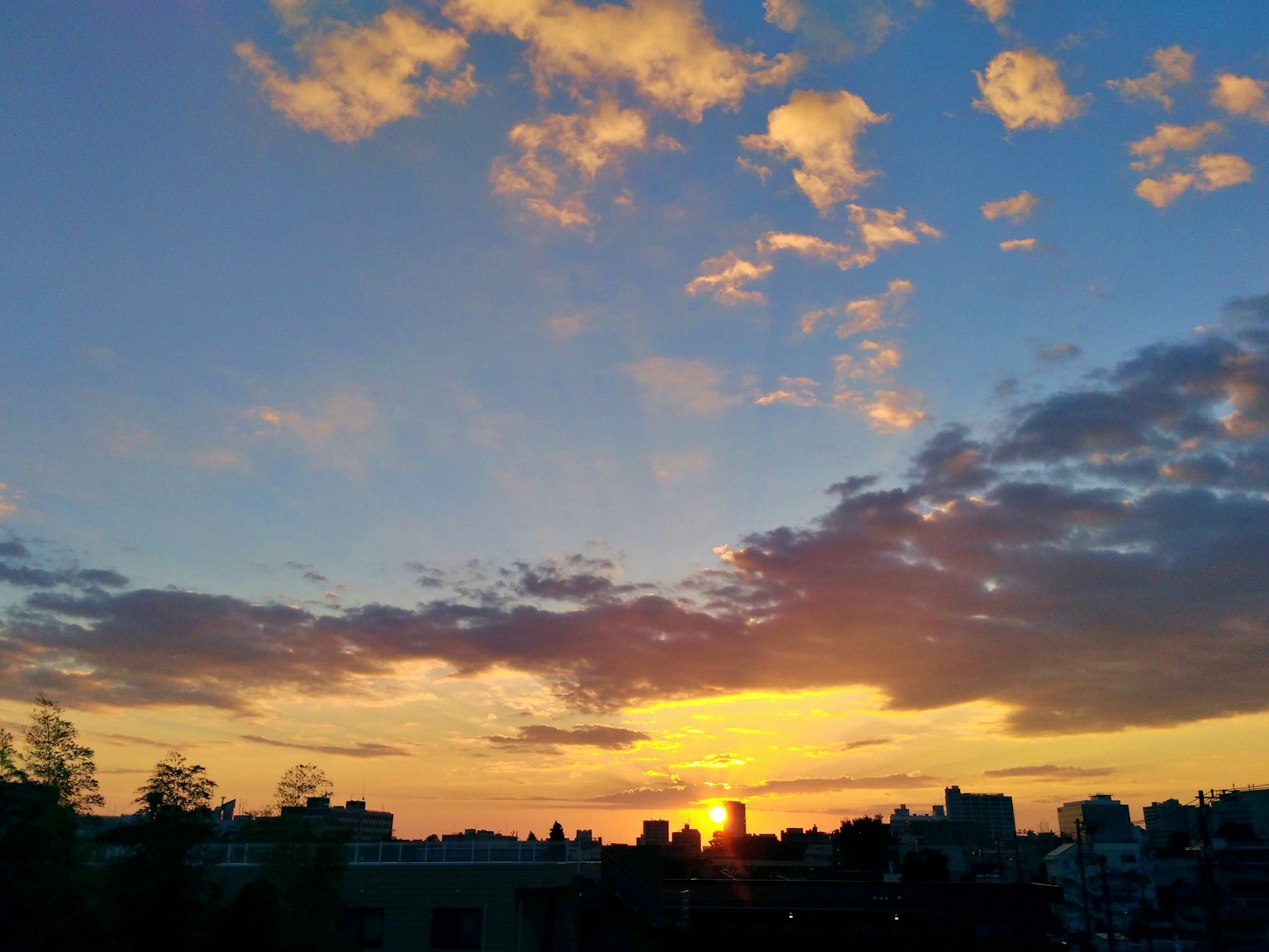夕阳下的天空，云朵和橙色光线